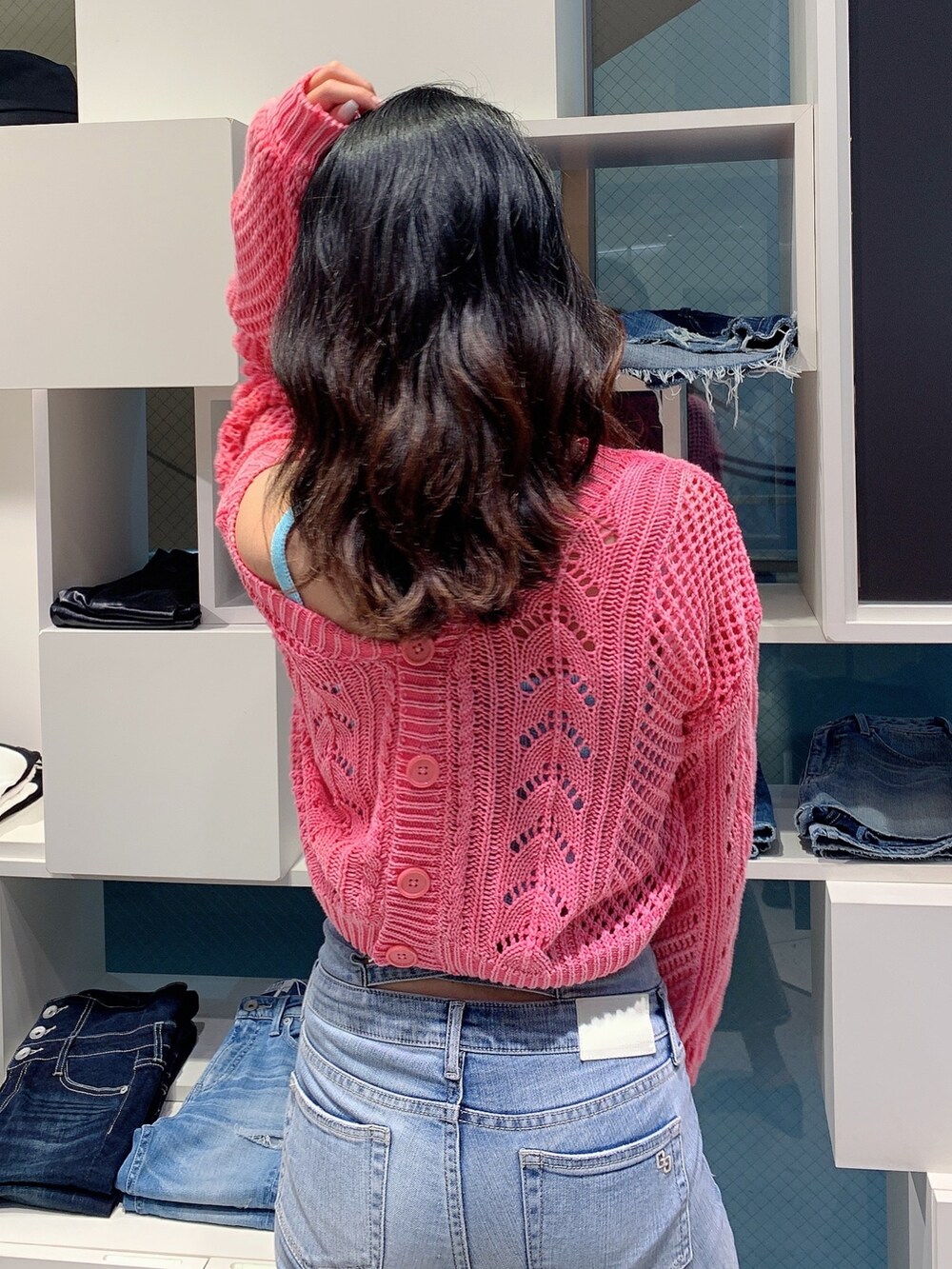 ブルー系のデニムパンツ、ブラック系のパンプス、ピンク系のカーディガン/ボレロを着用したレディースの春コーディネートの5枚目の写真