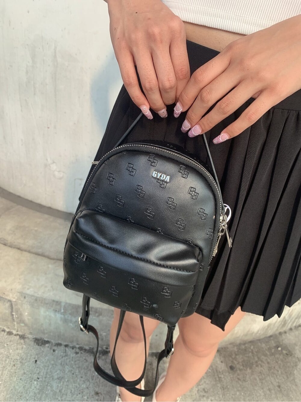 ブラック系のスカート、ブラック系のブーツ、ブラック系のバックパック/リュックを着用したレディースの夏コーディネートの10枚目の写真