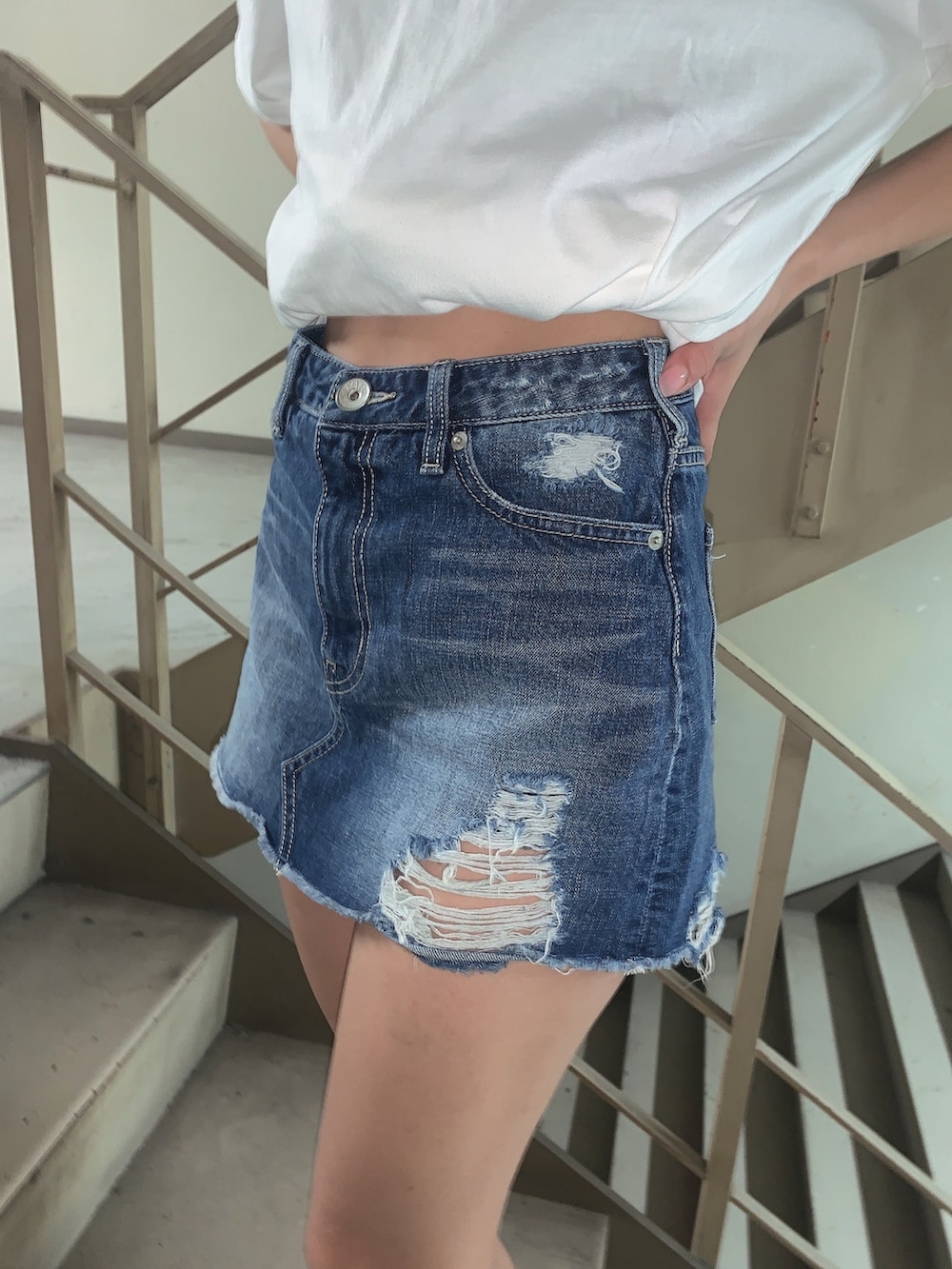 ブルー系のデニムスカート、ホワイト系のサンダル、ホワイト系のTシャツ/カットソーを着用したレディースの春コーディネートの8枚目の写真