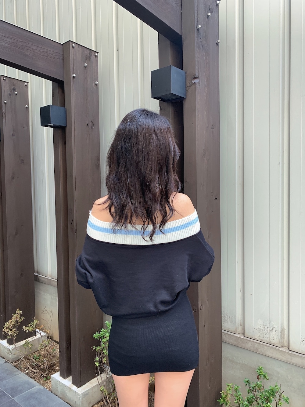 ブラック系のワンピース、ブラック系のブーツを着用したレディースの春コーディネートの5枚目の写真