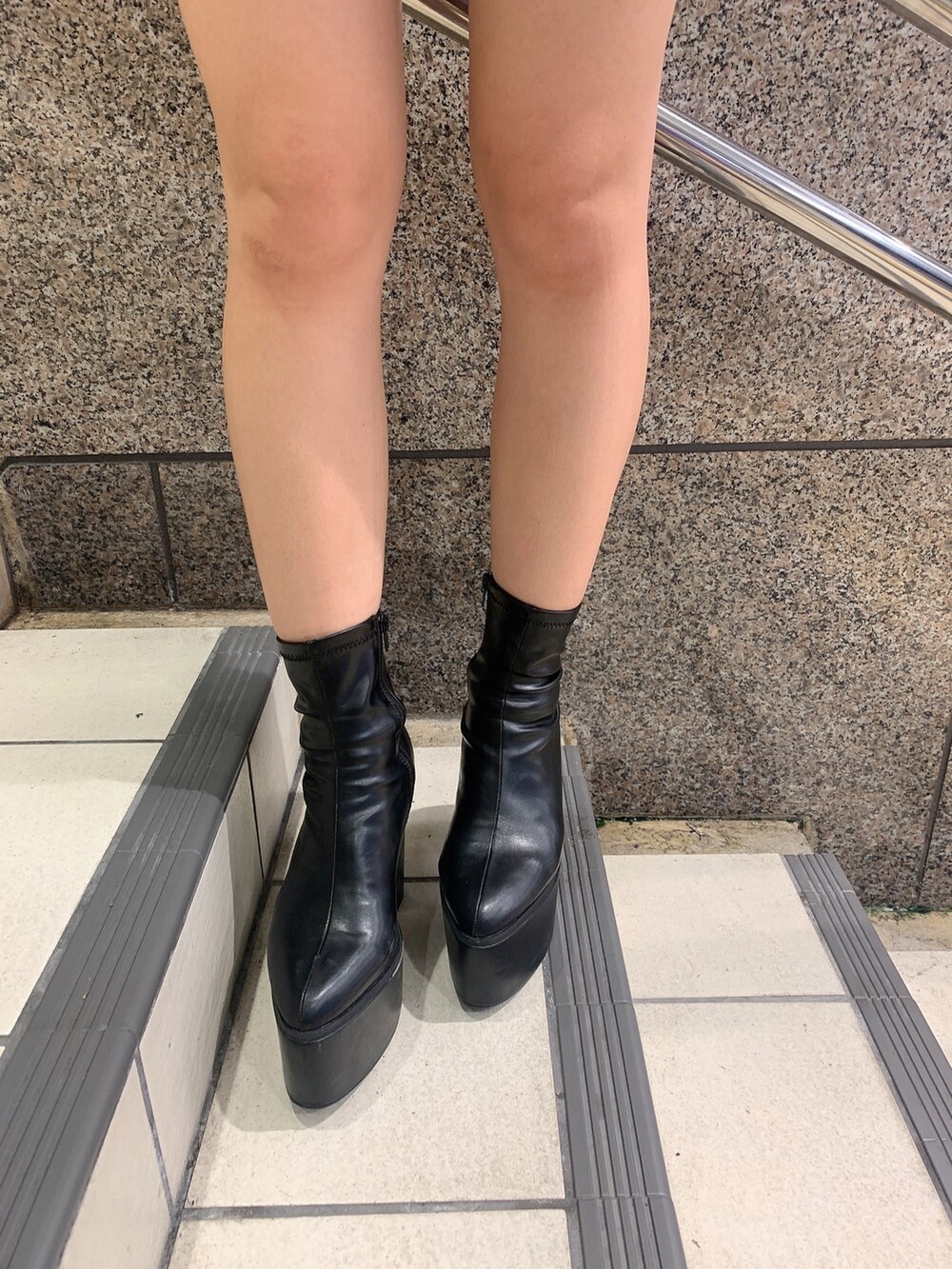 ブラック系のスカート、ブルー系のニット/セーター、ブラック系のブーツを着用したレディースの秋コーディネートの8枚目の写真