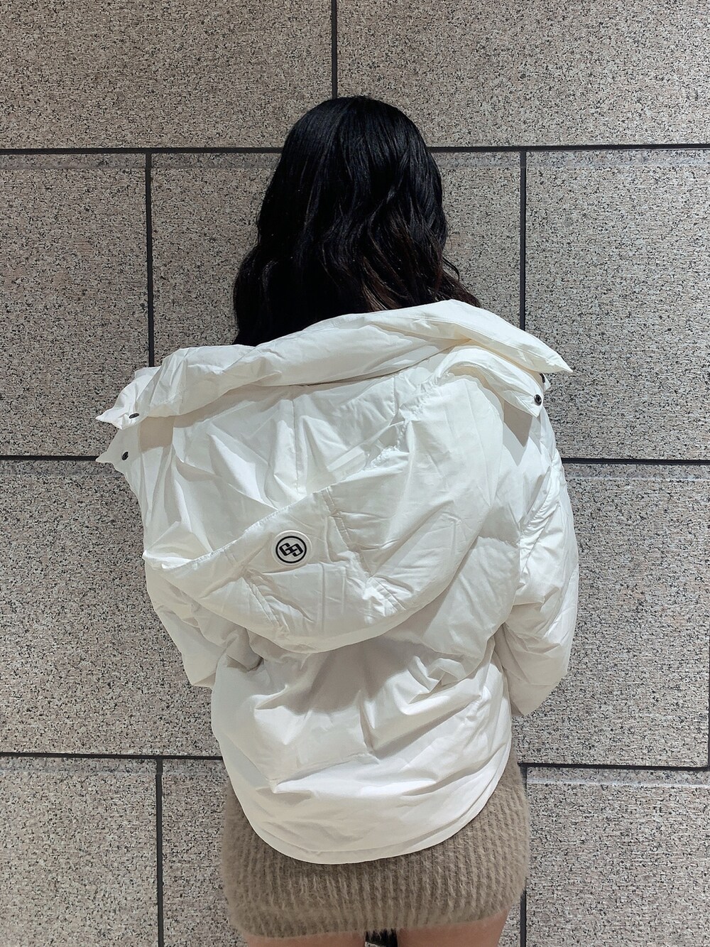 ブラック系のバックパック/リュック、ブラック系のブーツ、ホワイト系のダウンジャケット/コートを着用したレディースの冬コーディネートの4枚目の写真