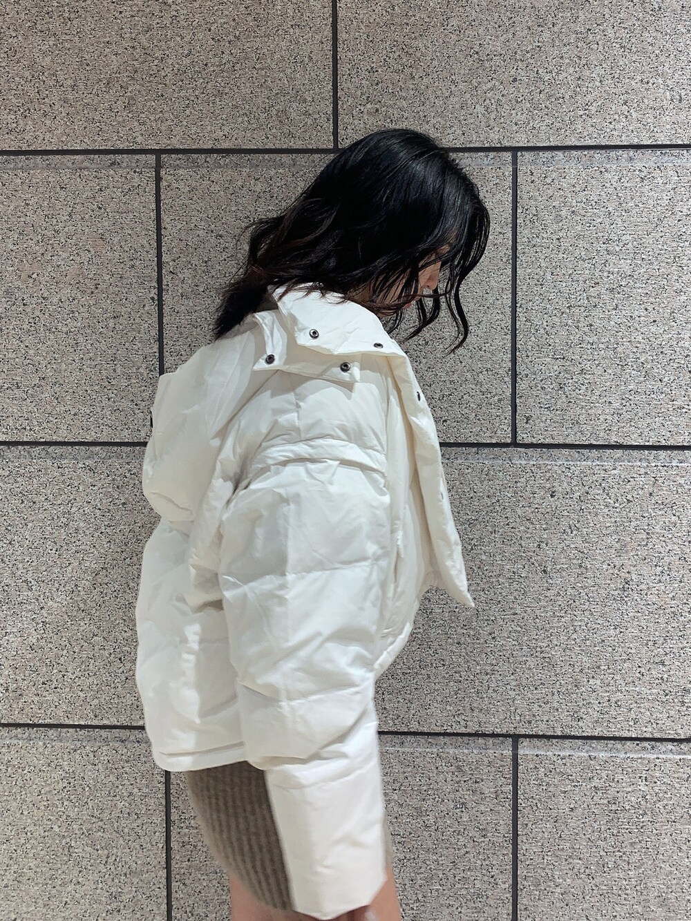 ブラック系のバックパック/リュック、ブラック系のブーツ、ホワイト系のダウンジャケット/コートを着用したレディースの冬コーディネートの5枚目の写真