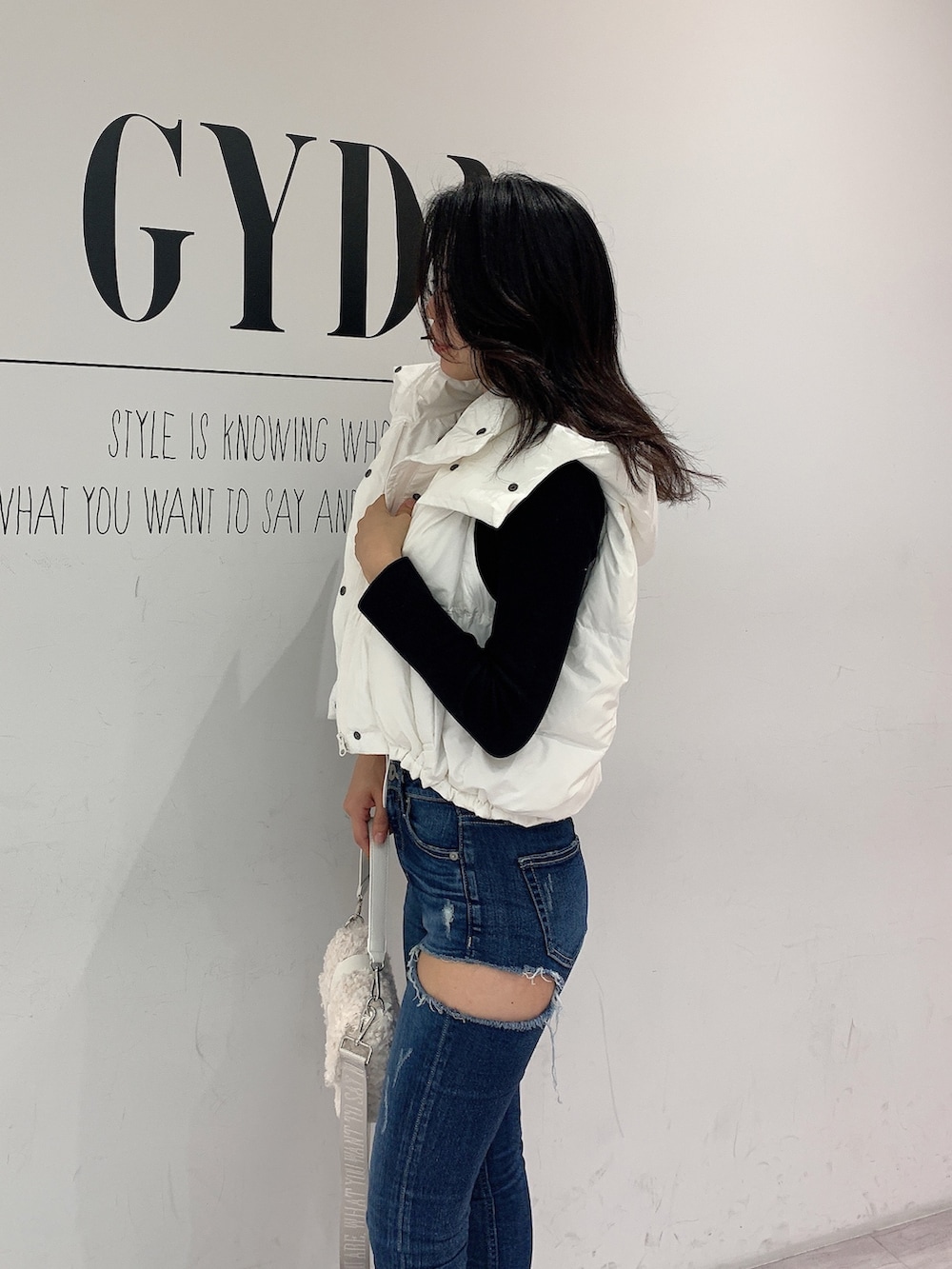 ブルー系のデニムパンツ、ブラック系のブーツ、ブラック系のニット/セーターを着用したレディースの秋コーディネートの6枚目の写真
