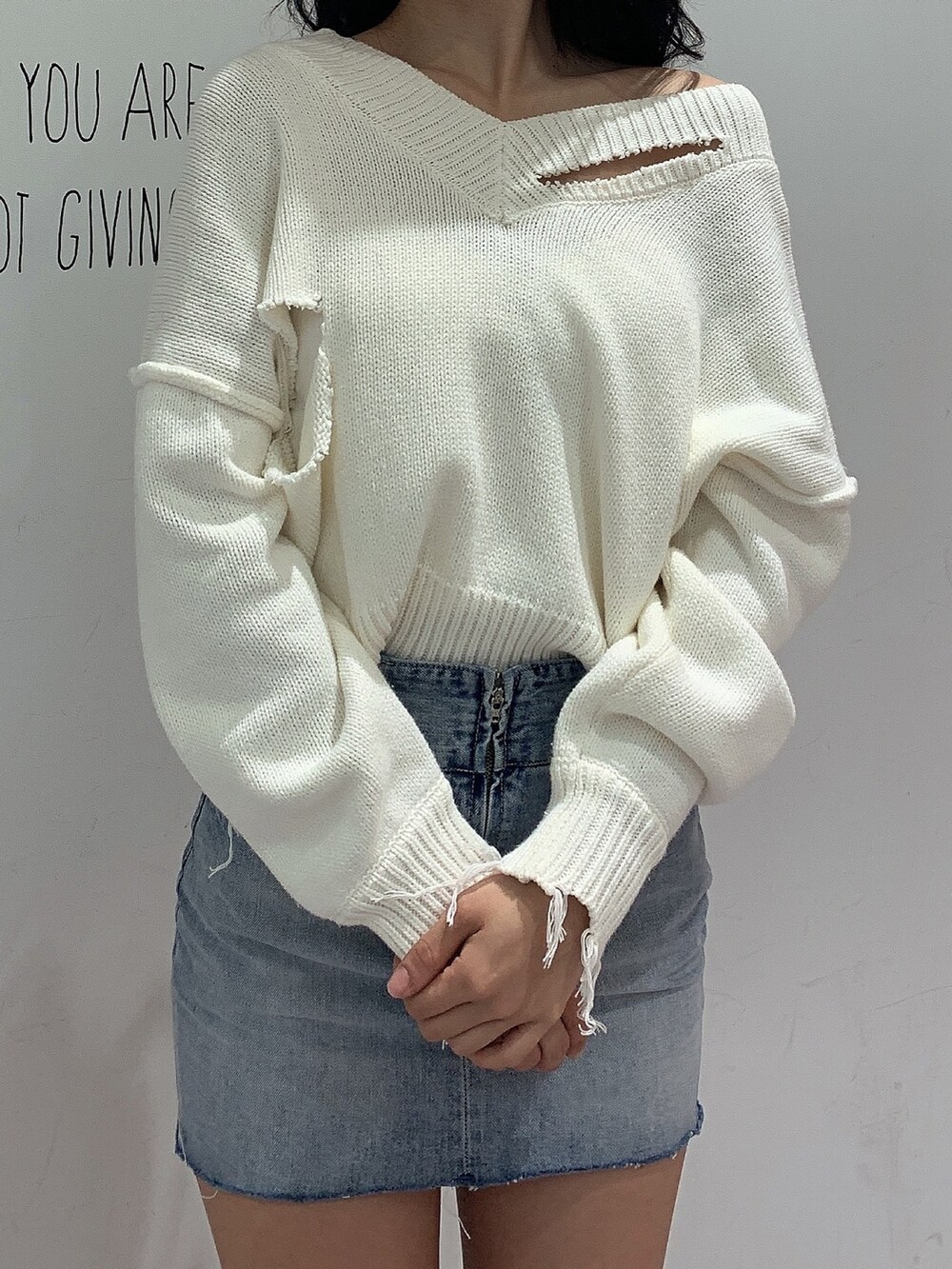 ブルー系のスカート、ブラック系のブーツ、ホワイト系のニット/セーターを着用したレディースの冬コーディネートの4枚目の写真