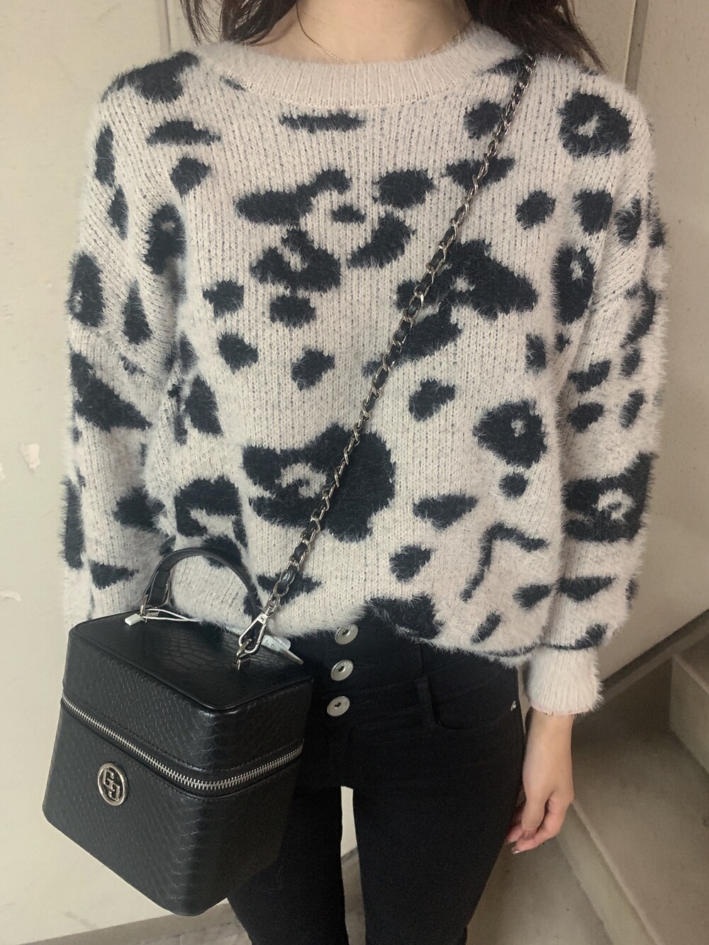 ブラック系のブーツ、ブラック系のデニムパンツ、ホワイト系のニット/セーターを着用したレディースの冬コーディネートの7枚目の写真