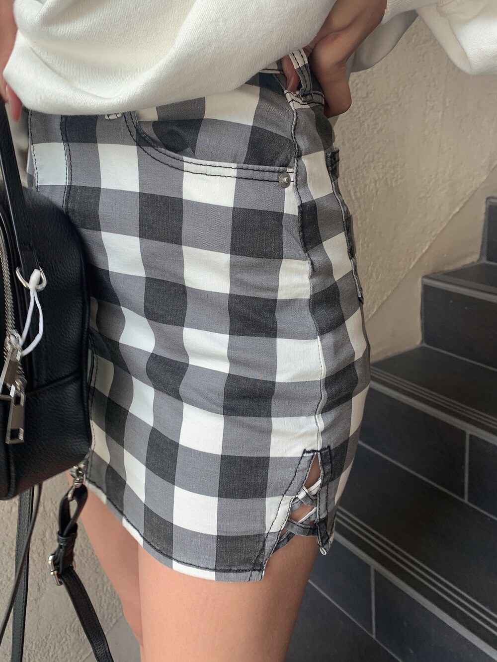 ホワイト系のスウェット、その他のスカート、ブラック系のブーツを着用したレディースの冬コーディネートの6枚目の写真