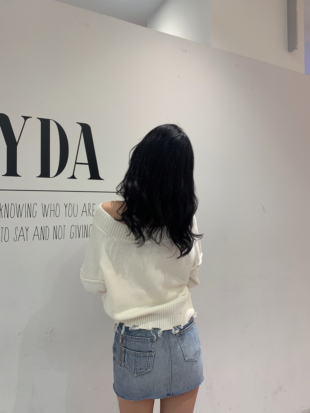 ブルー系のスカート、ブラック系のブーツ、ホワイト系のニット/セーターを着用したレディースの冬コーディネートの5枚目の写真