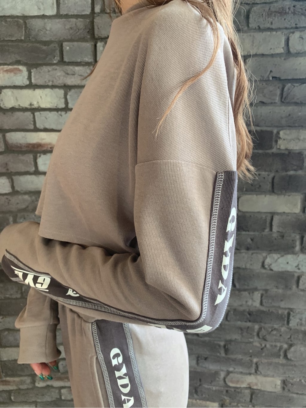 ベージュ系のその他パンツ、ホワイト系のサンダル、ベージュ系のパーカーを着用したレディースの夏コーディネートの6枚目の写真