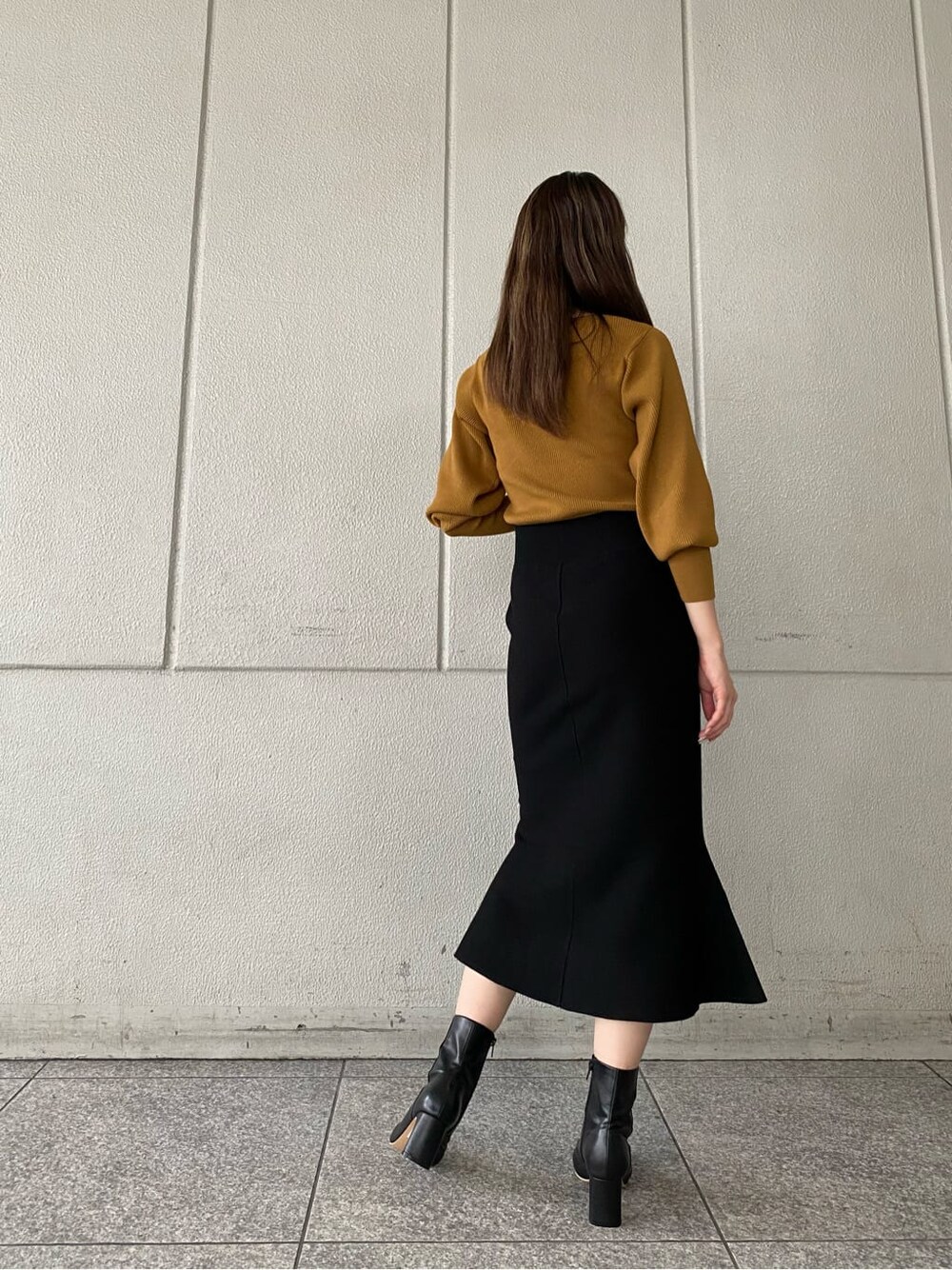ブラック系のその他シューズ、ブラック系のスカート、イエロー系のニット/セーターを着用したレディースの秋コーディネートの5枚目の写真
