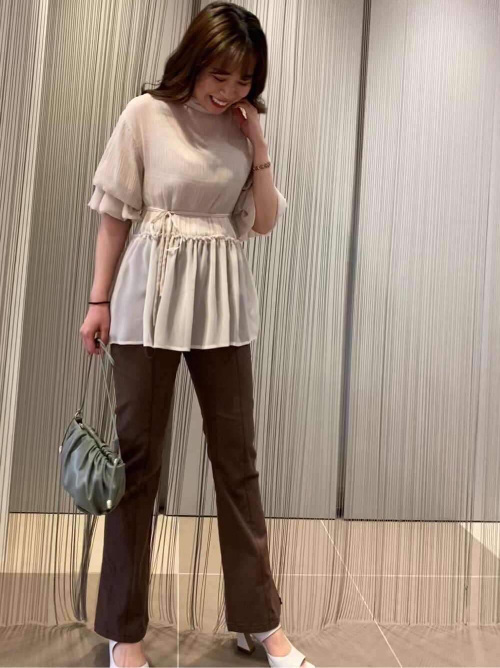 ブラウン系のその他パンツ、ホワイト系のサンダル、ホワイト系のシャツ/ブラウスを着用したレディースの春コーディネートの2枚目の写真