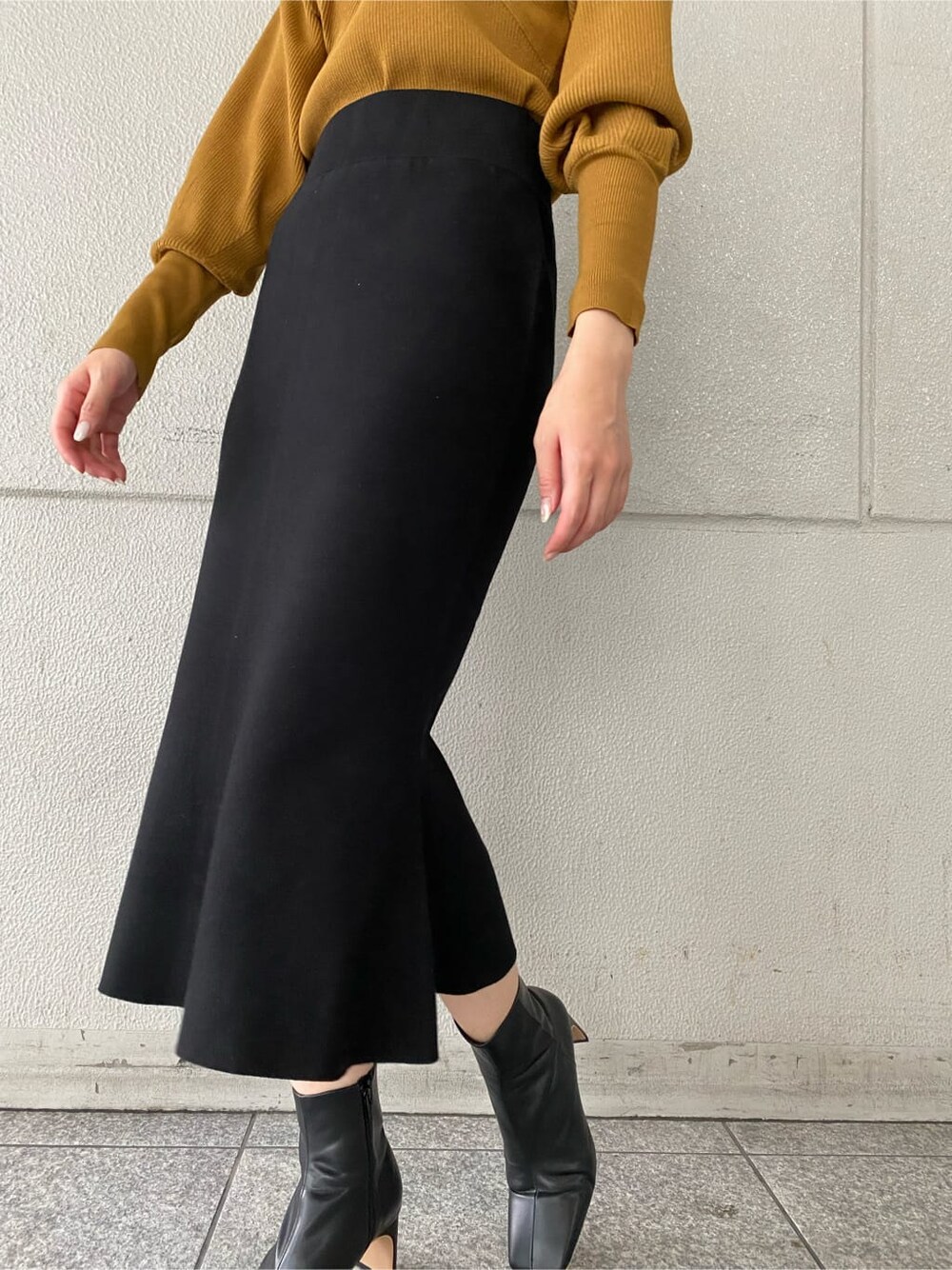 ブラック系のその他シューズ、ブラック系のスカート、イエロー系のニット/セーターを着用したレディースの秋コーディネートの6枚目の写真