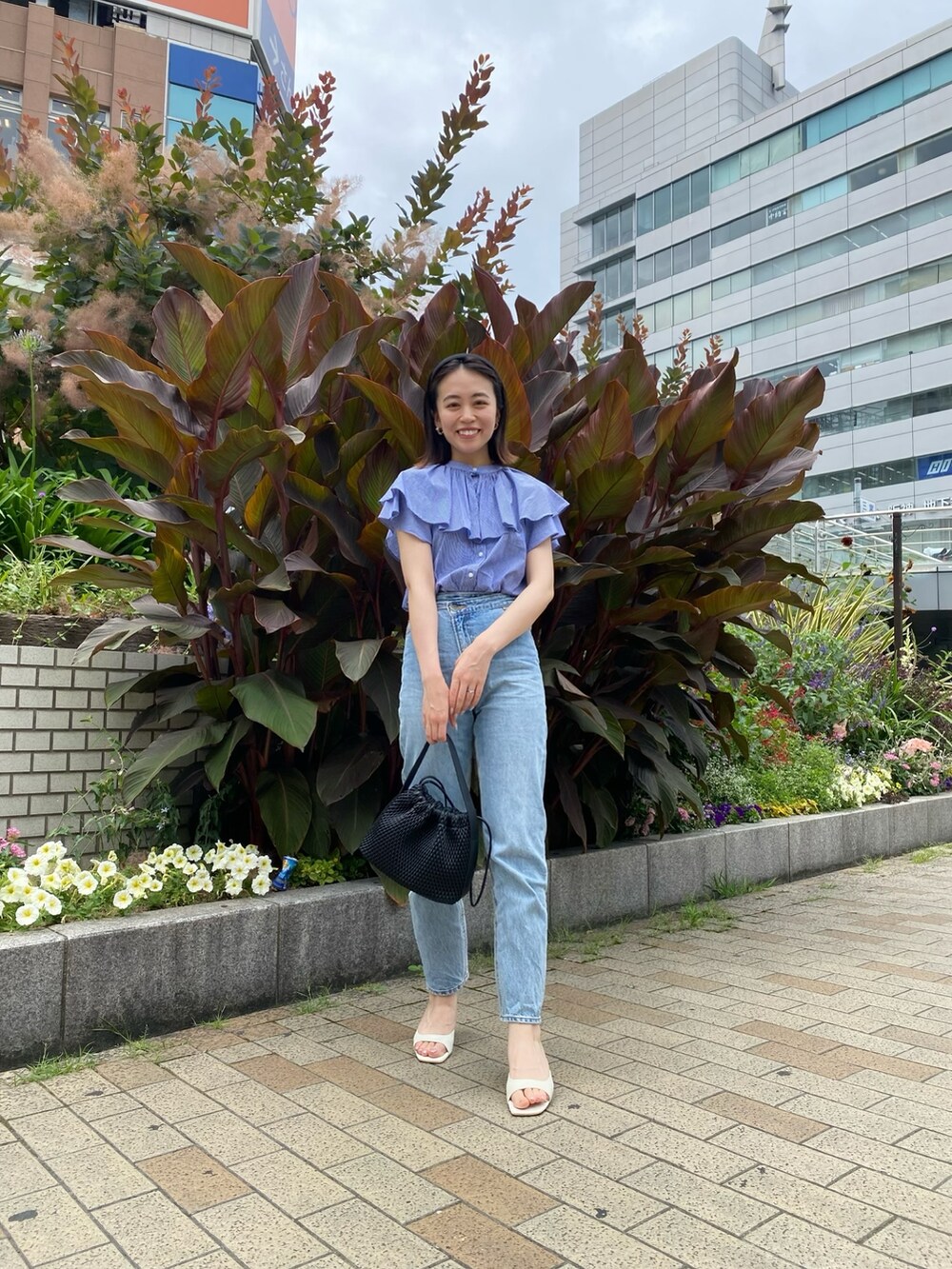 ブルー系のシャツ/ブラウス、ブルー系のデニムパンツ、ブラック系のハンドバッグを着用したレディースの夏コーディネートの2枚目の写真