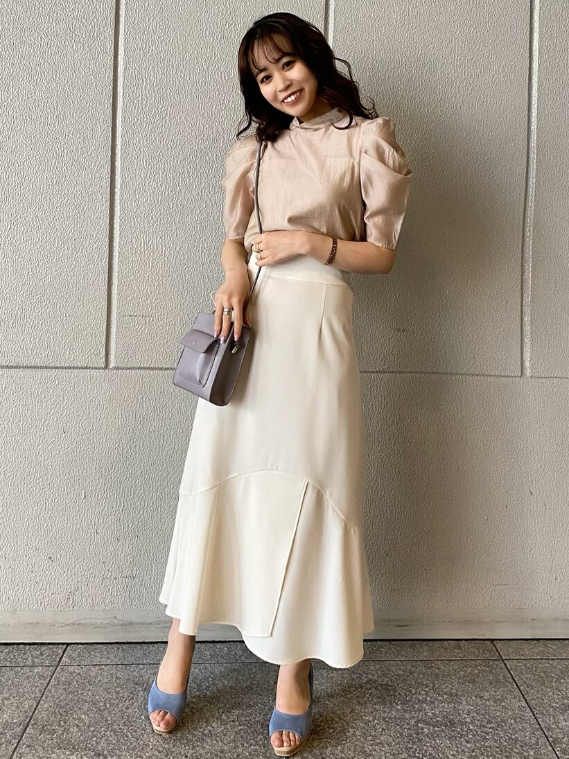 ベージュ系のシャツ/ブラウス、ブルー系のパンプス、パープル系のハンドバッグを着用したレディースの春コーディネートの2枚目の写真