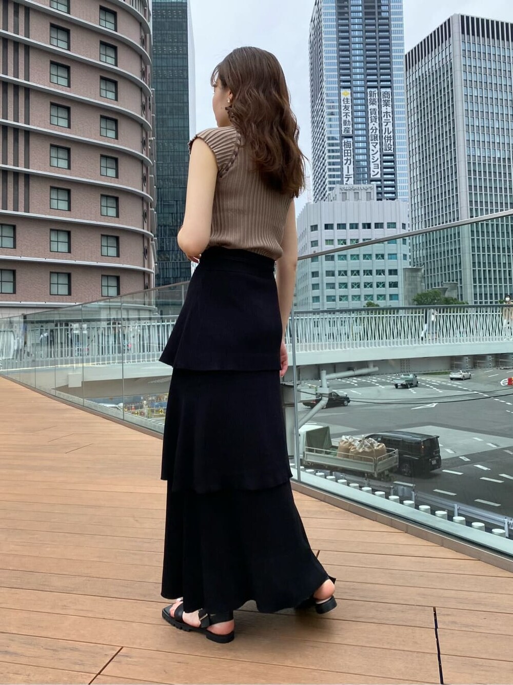 ブラック系のスカート、ブラック系のサンダル、ベージュ系のニット/セーターを着用したレディースの夏コーディネートの5枚目の写真