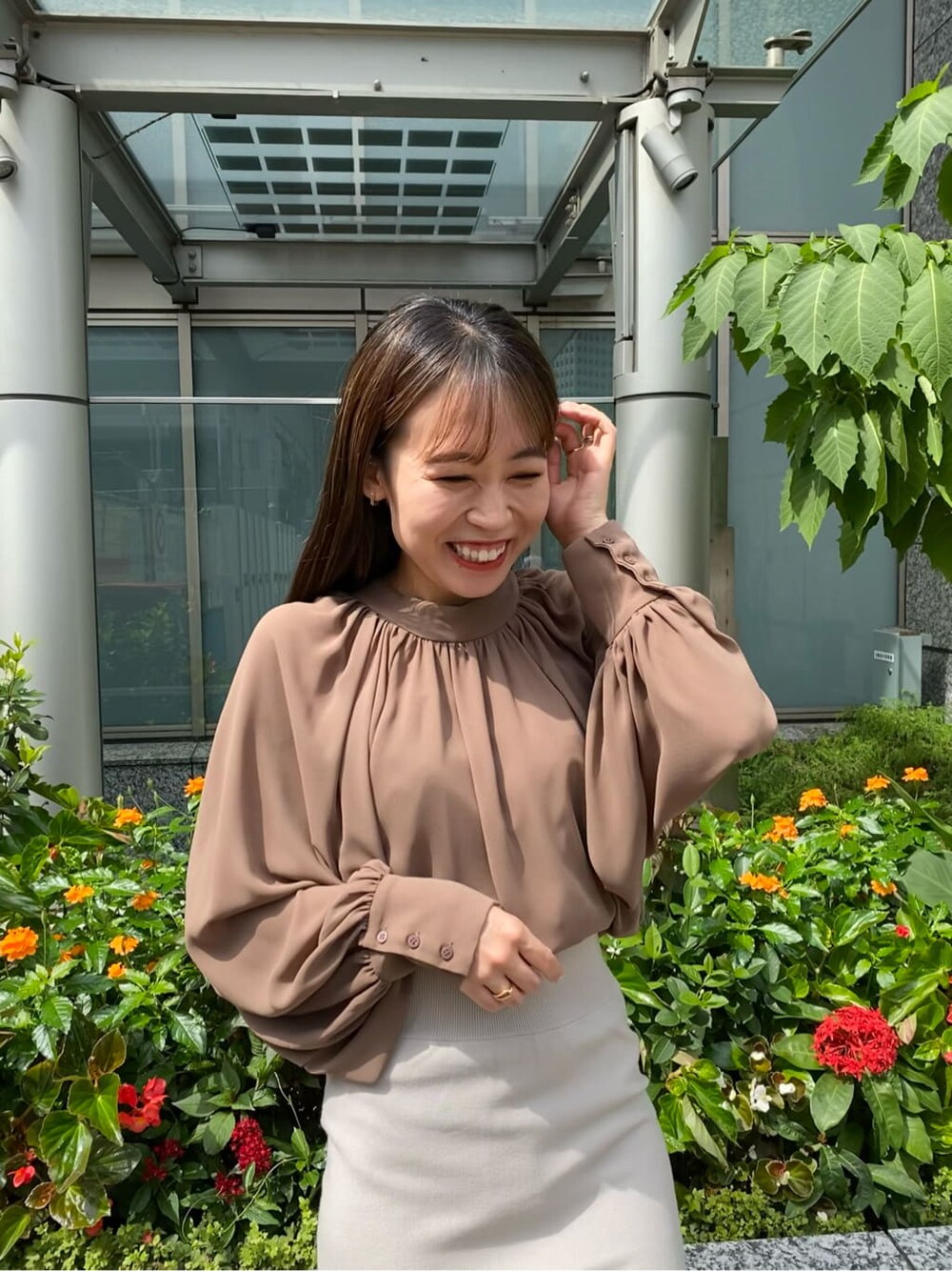 グレー系のスカート、ホワイト系のその他シューズ、ブラウン系のシャツ/ブラウスを着用したレディースの秋コーディネートの4枚目の写真