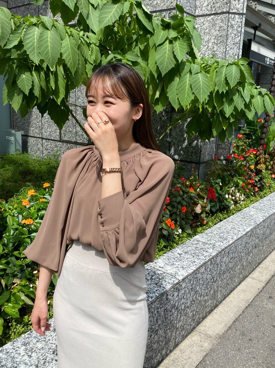 グレー系のスカート、ホワイト系のその他シューズ、ブラウン系のシャツ/ブラウスを着用したレディースの秋コーディネートの2枚目の写真