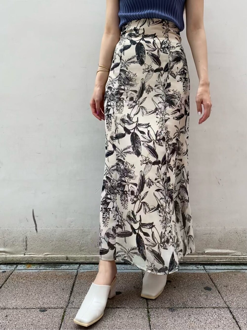 ベージュ系のスカート、ブルー系のニット/セーターを着用したレディースの夏コーディネートの3枚目の写真