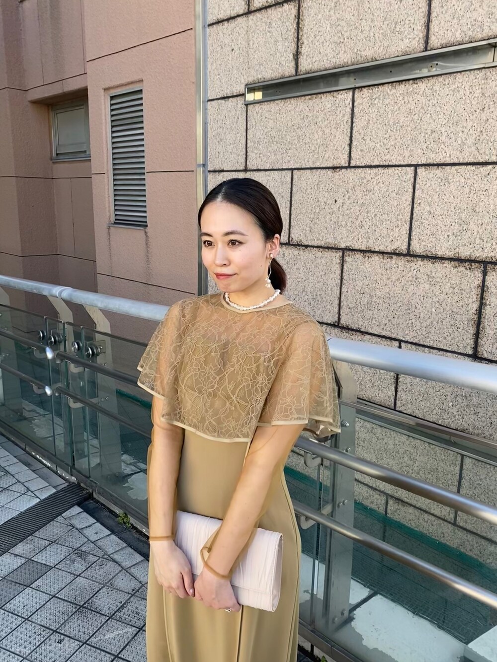 ベージュ系のドレス、ベージュ系のテーラードジャケット、ベージュ系のハンドバッグを着用したレディースの秋コーディネートの3枚目の写真