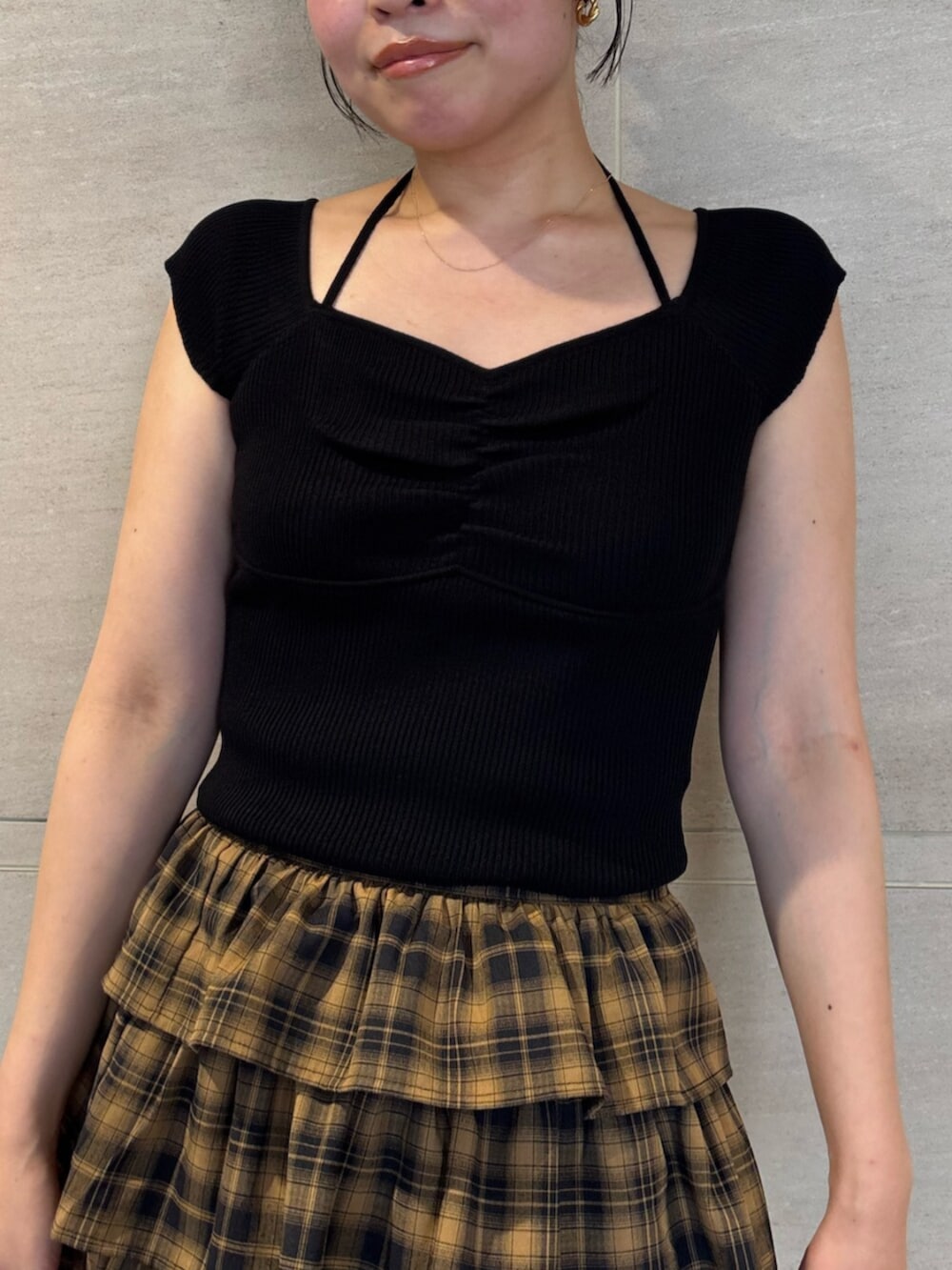ブラック系のサンダル、ブラック系のニット/セーター、イエロー系のスカートを着用したレディースの夏コーディネートの4枚目の写真