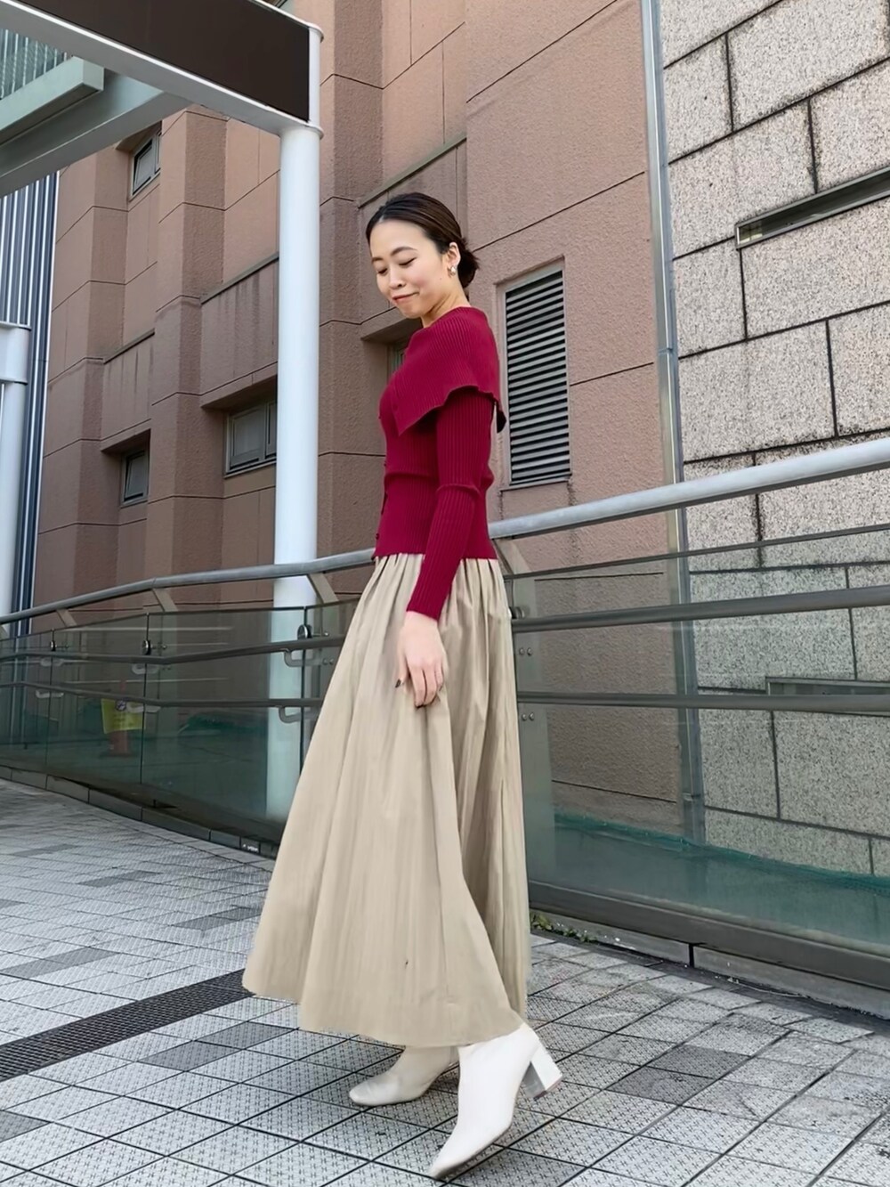 レッド系のニット/セーター、ベージュ系のスカートを着用したレディースの冬コーディネートの4枚目の写真