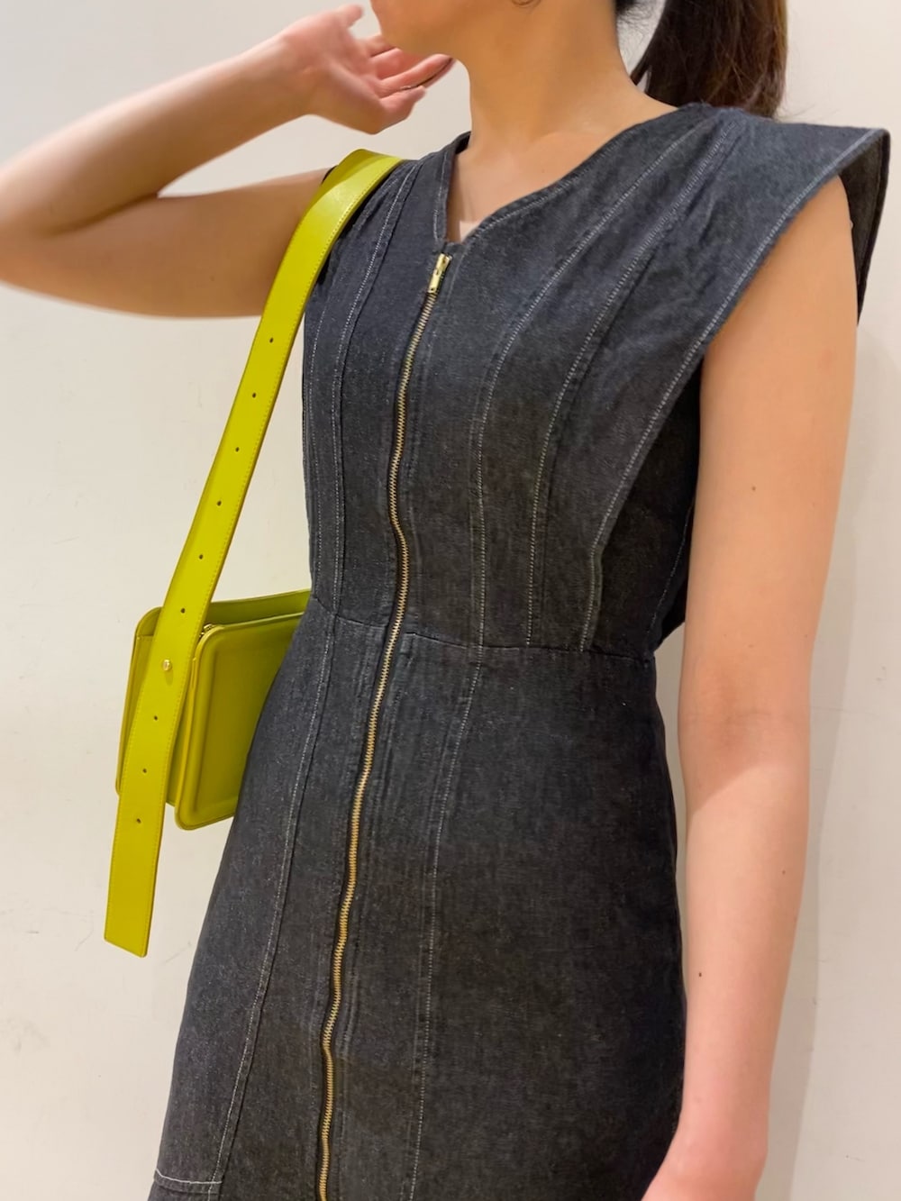 ブラック系のワンピース、グリーン系のショルダーバッグを着用したレディースの春コーディネートの2枚目の写真