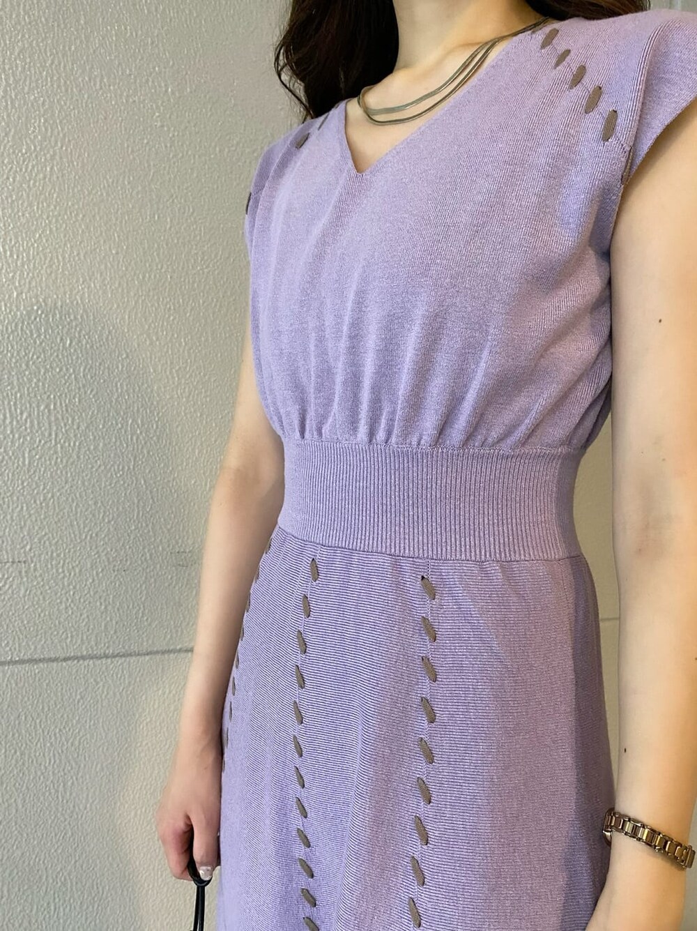 ブラウン系のパンプス、ブラック系のハンドバッグ、パープル系のワンピースを着用したレディースの夏コーディネートの5枚目の写真