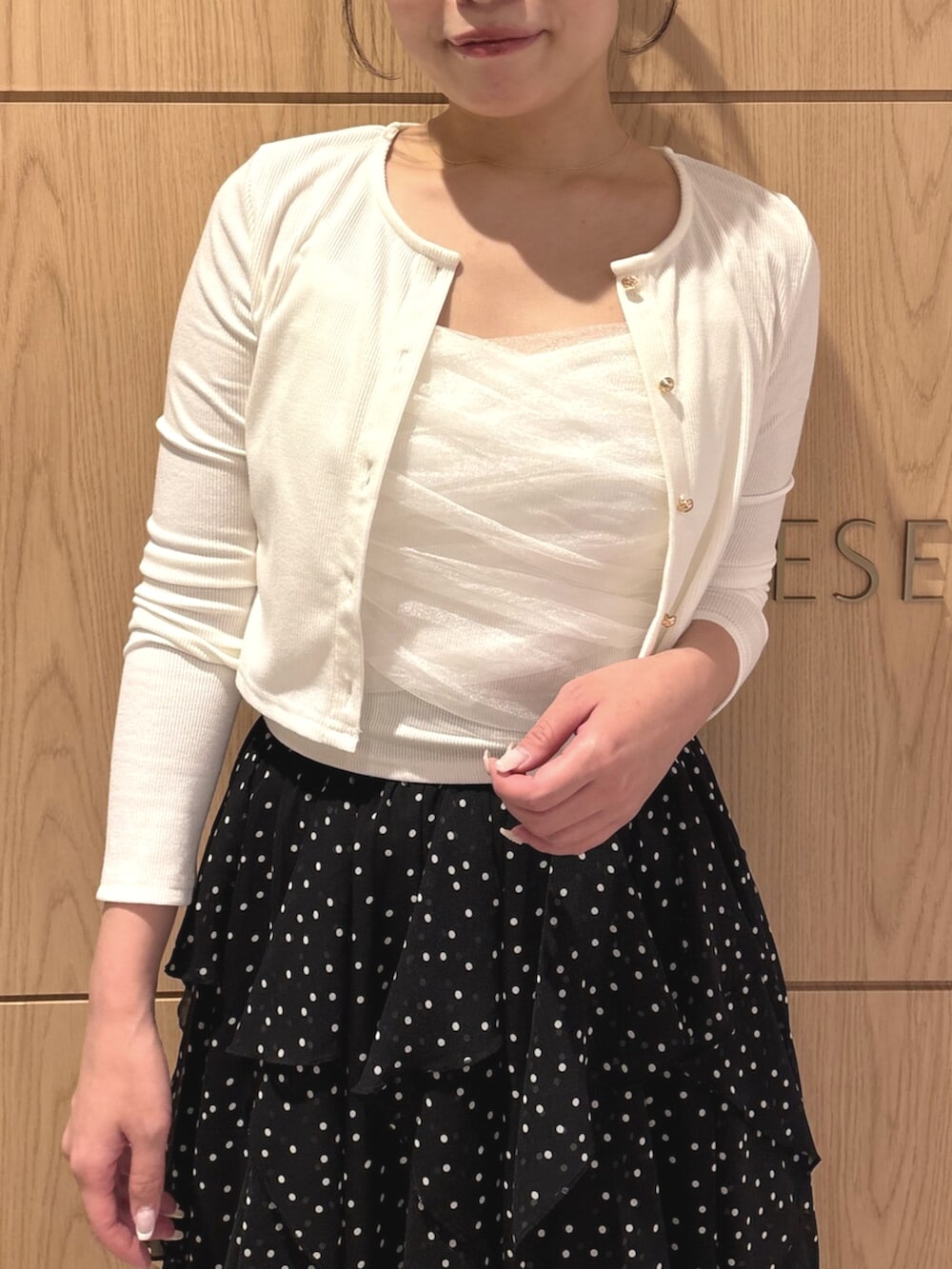 ブラック系のパンプス、ホワイト系のカーディガン/ボレロ、ホワイト系のスカートを着用したレディースの秋コーディネートの4枚目の写真