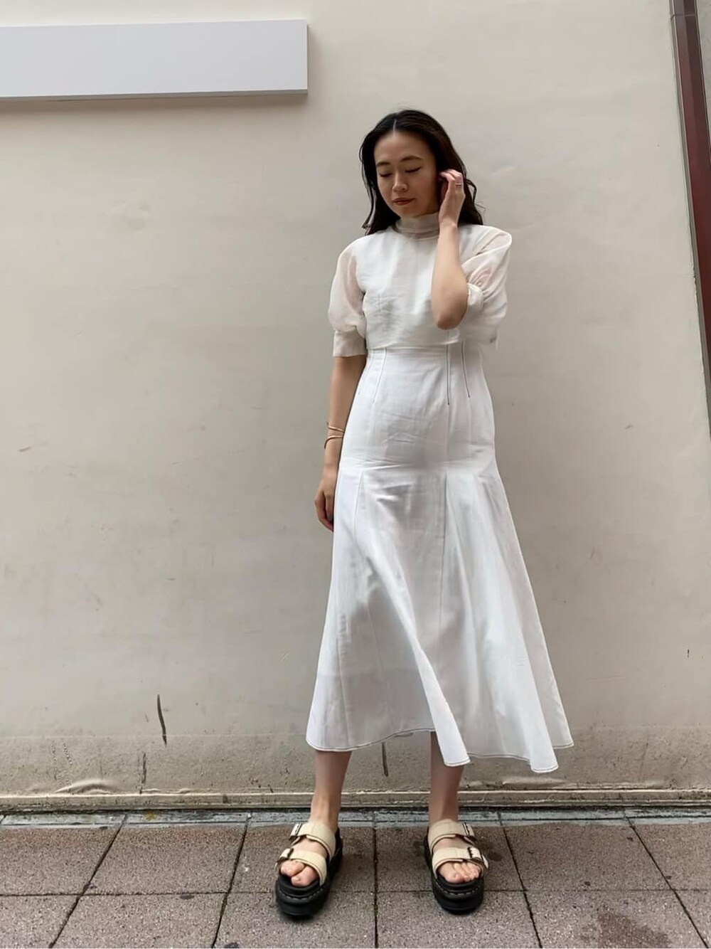 ベージュ系のサンダル、ホワイト系のワンピースを着用したレディースの夏コーディネートの3枚目の写真