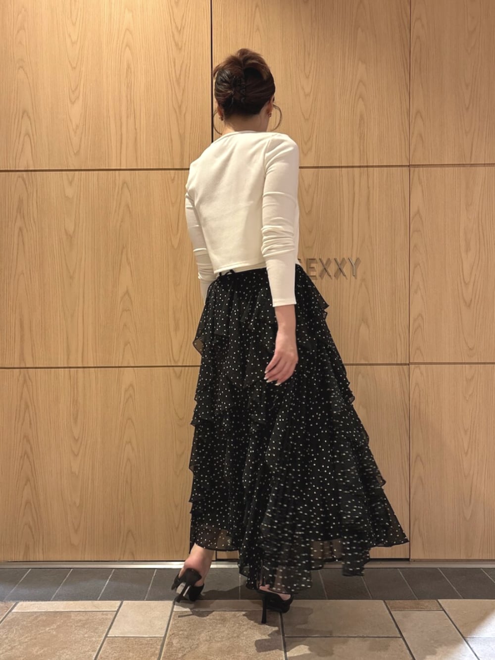 ブラック系のパンプス、ホワイト系のカーディガン/ボレロ、ホワイト系のスカートを着用したレディースの秋コーディネートの3枚目の写真