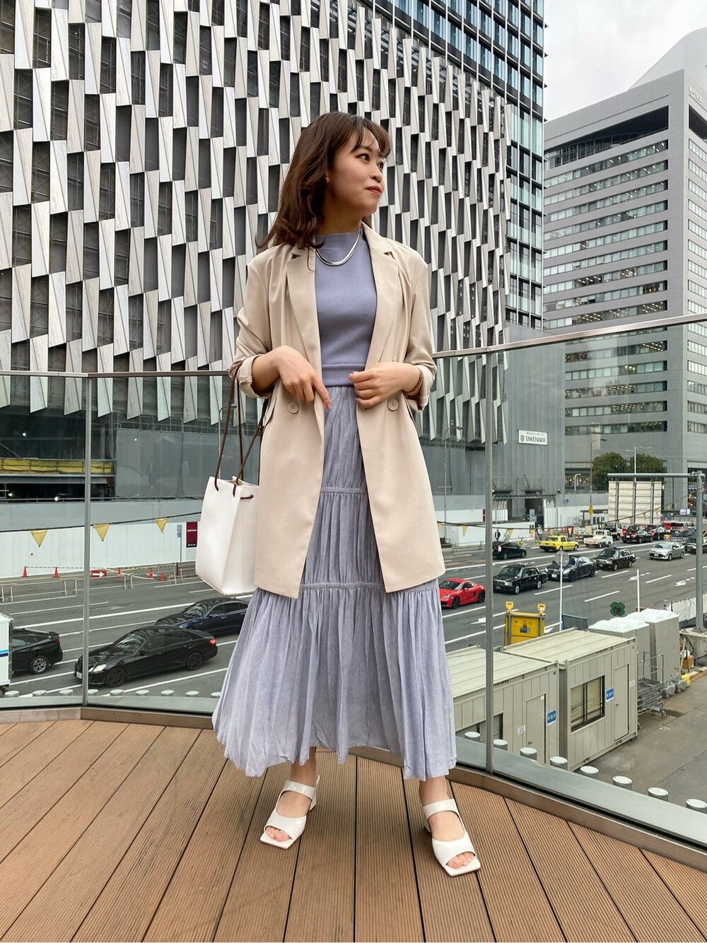 ホワイト系のサンダル、ホワイト系のハンドバッグ、ブルー系のワンピースを着用したレディースの春コーディネートの3枚目の写真