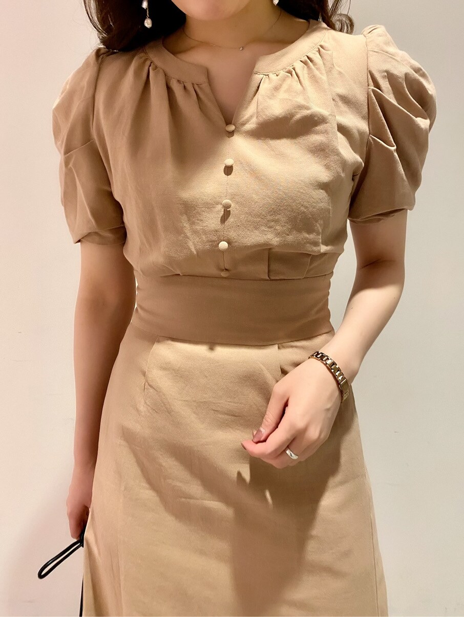 ブラウン系のパンプス、ブラック系のハンドバッグ、ベージュ系のワンピースを着用したレディースの春コーディネートの3枚目の写真