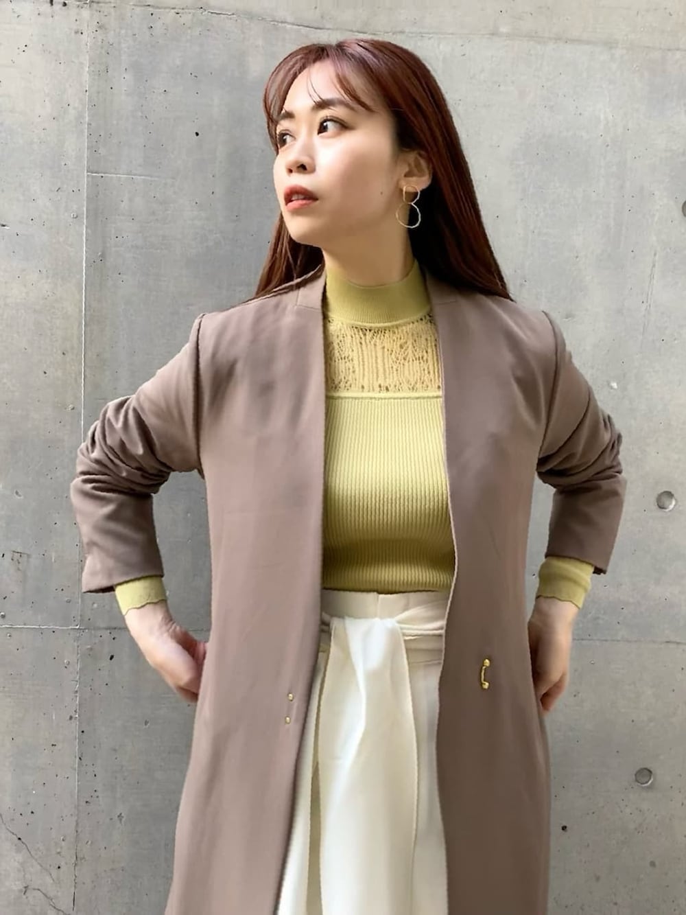 ホワイト系のその他パンツ、ベージュ系のノーカラーコート、イエロー系のニット/セーターを着用したレディースの冬コーディネートの2枚目の写真