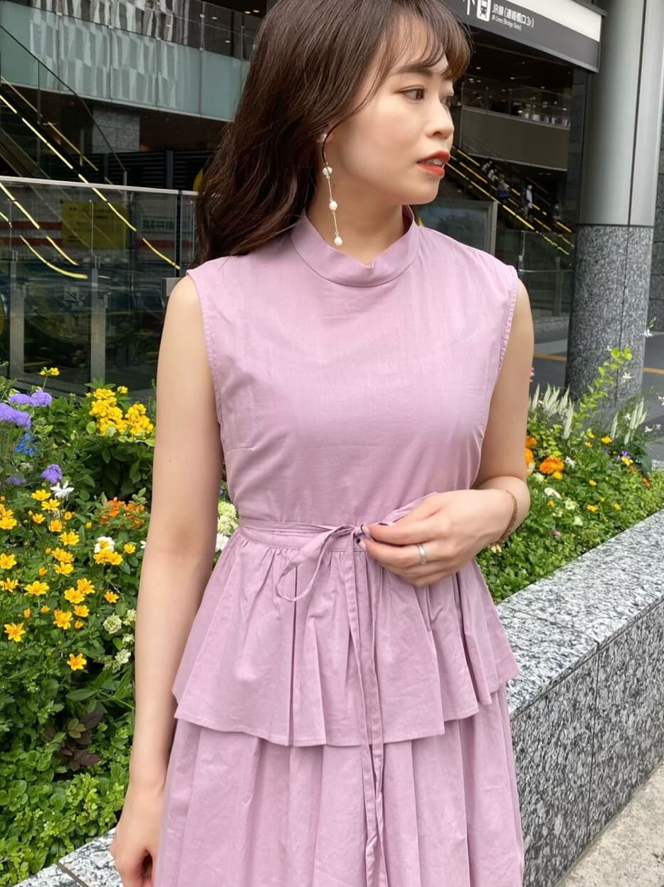 パープル系のワンピース、ブラック系のサンダル、ベージュ系のハンドバッグを着用したレディースの夏コーディネートの5枚目の写真