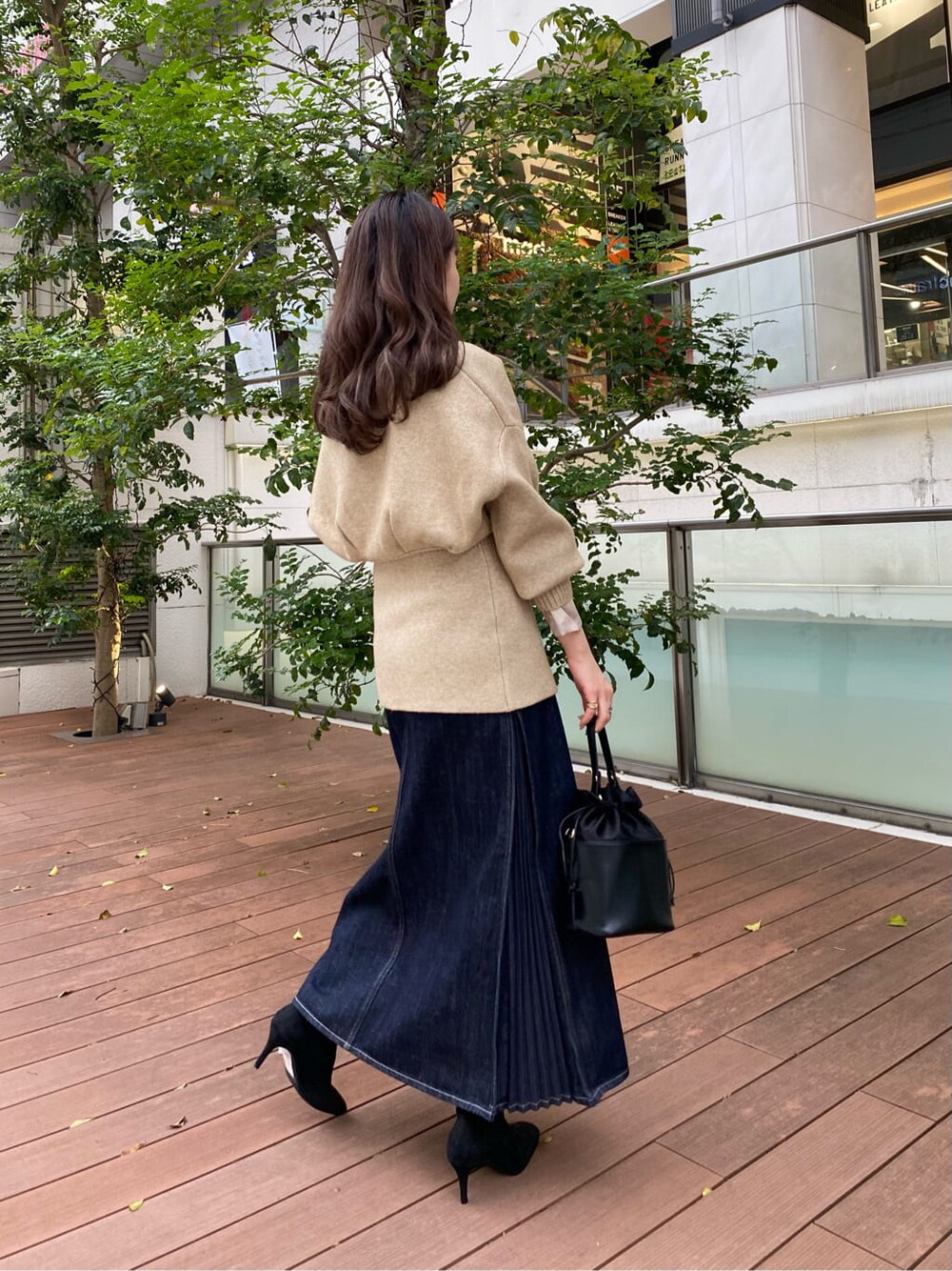 ブラック系のハンドバッグ、ブラック系のブーツ、ブラウン系のシャツ/ブラウスを着用したレディースの秋コーディネートの6枚目の写真