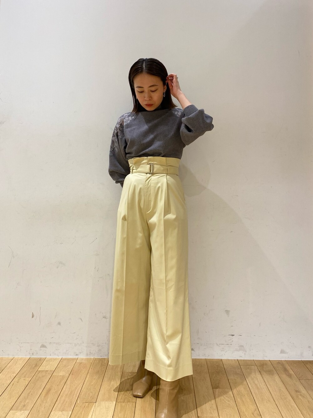グレー系のニット/セーター、イエロー系のその他パンツ、ブラック系のステンカラーコートを着用したレディースの夏コーディネートの2枚目の写真