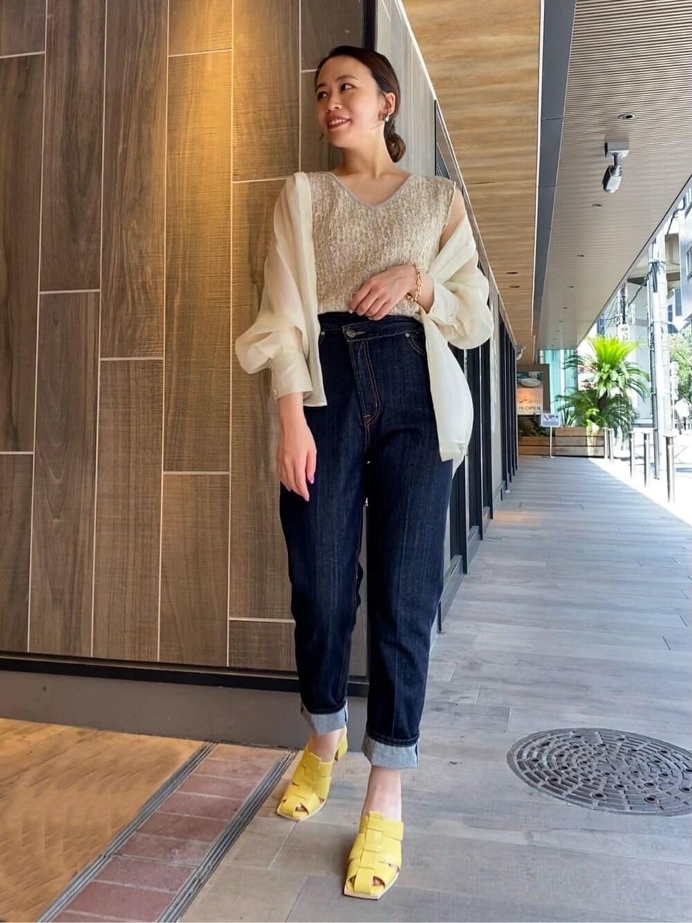 ホワイト系のシャツ/ブラウス、ブルー系のデニムパンツ、イエロー系のサンダルを着用したレディースの夏コーディネートの2枚目の写真