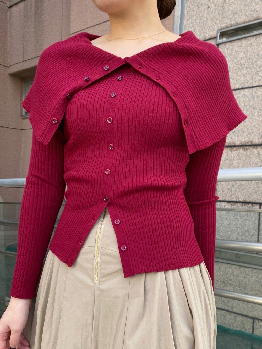 レッド系のニット/セーター、ベージュ系のスカートを着用したレディースの冬コーディネートの3枚目の写真