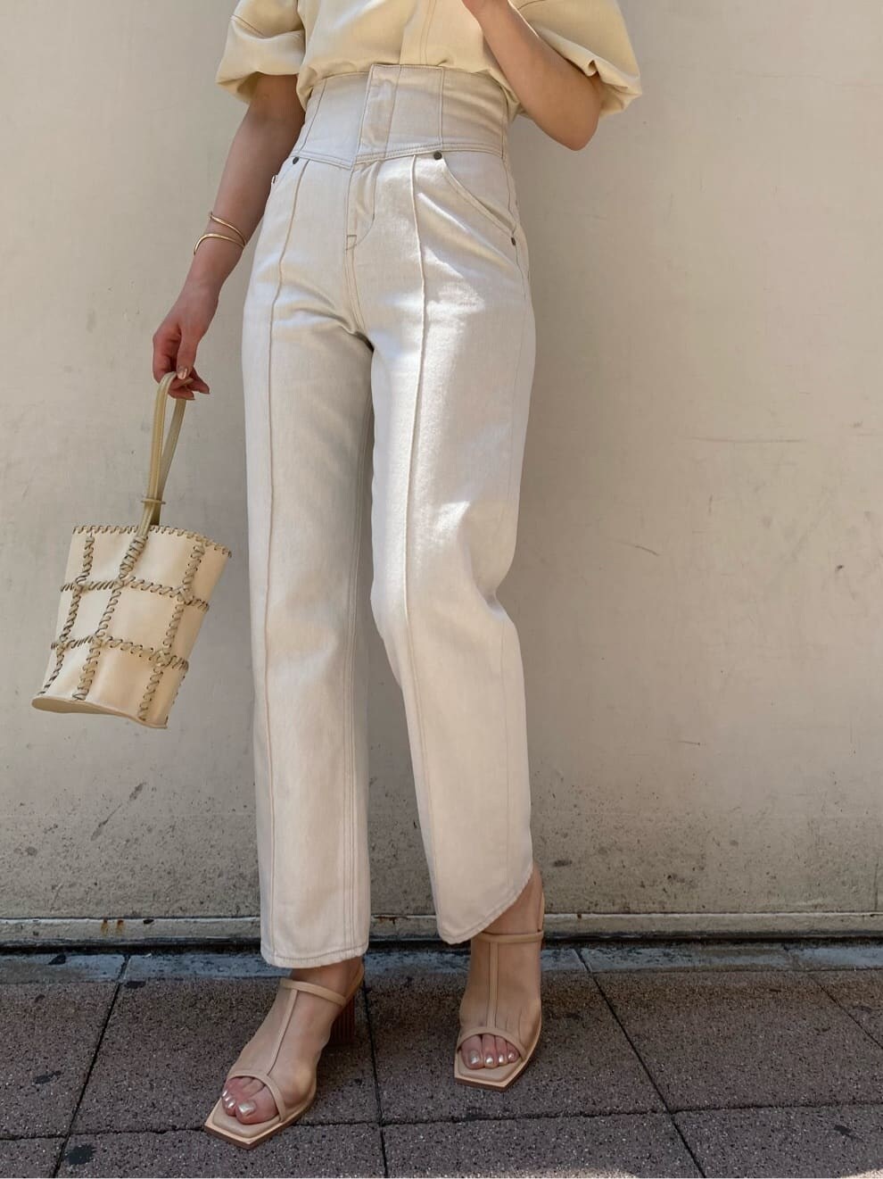 ホワイト系のデニムパンツ、ホワイト系のショルダーバッグ、ベージュ系のサンダルを着用したレディースの夏コーディネートの4枚目の写真