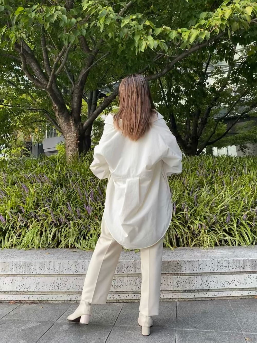ホワイト系のステンカラーコート、ホワイト系のその他パンツ、ホワイト系のハンドバッグを着用したレディースの秋コーディネートの6枚目の写真