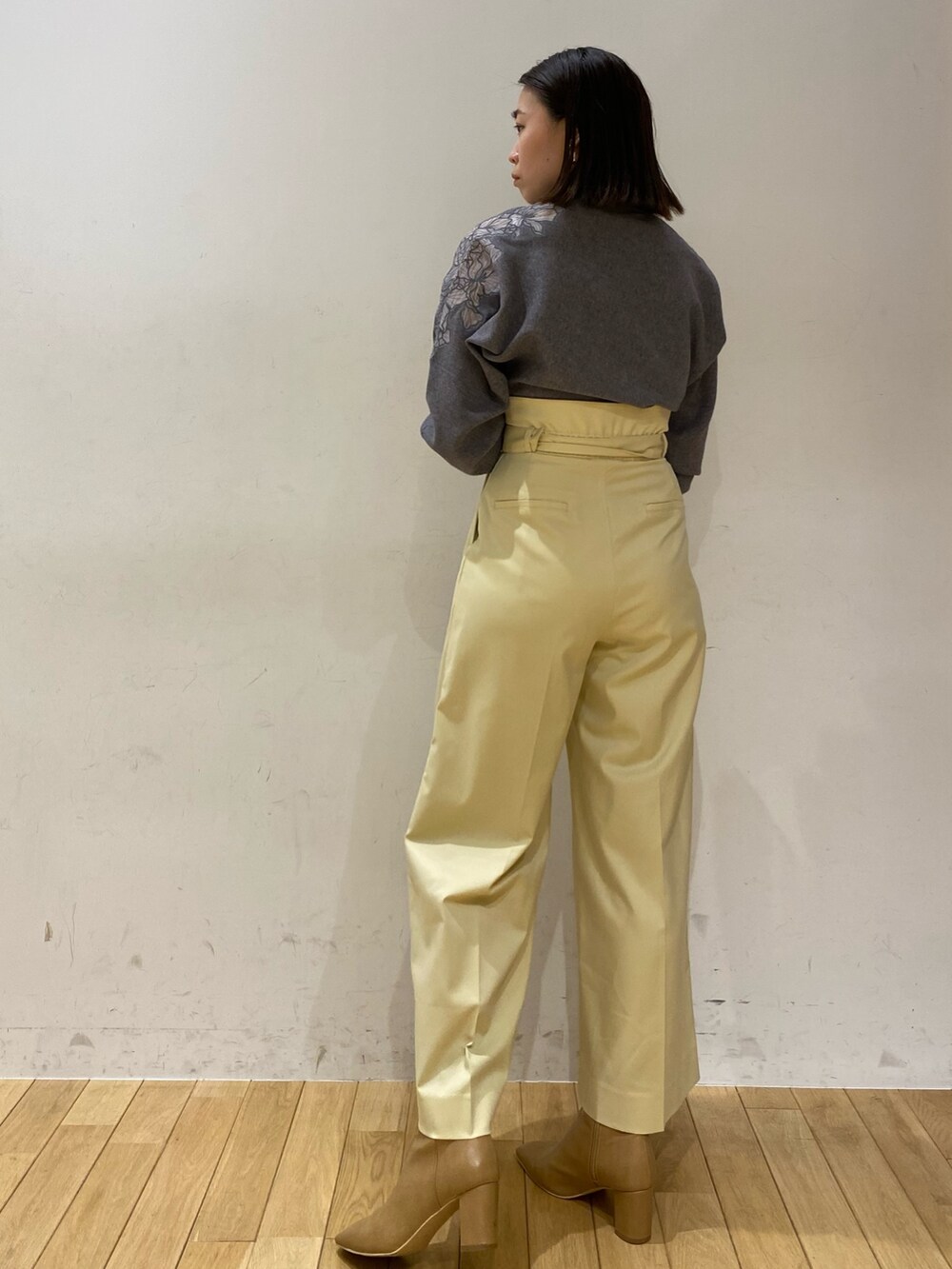 グレー系のニット/セーター、イエロー系のその他パンツ、ブラック系のステンカラーコートを着用したレディースの夏コーディネートの3枚目の写真
