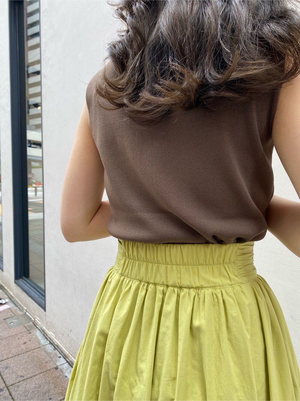 ブラウン系のニット/セーター、グリーン系のスカートを着用したレディースの夏コーディネートの3枚目の写真