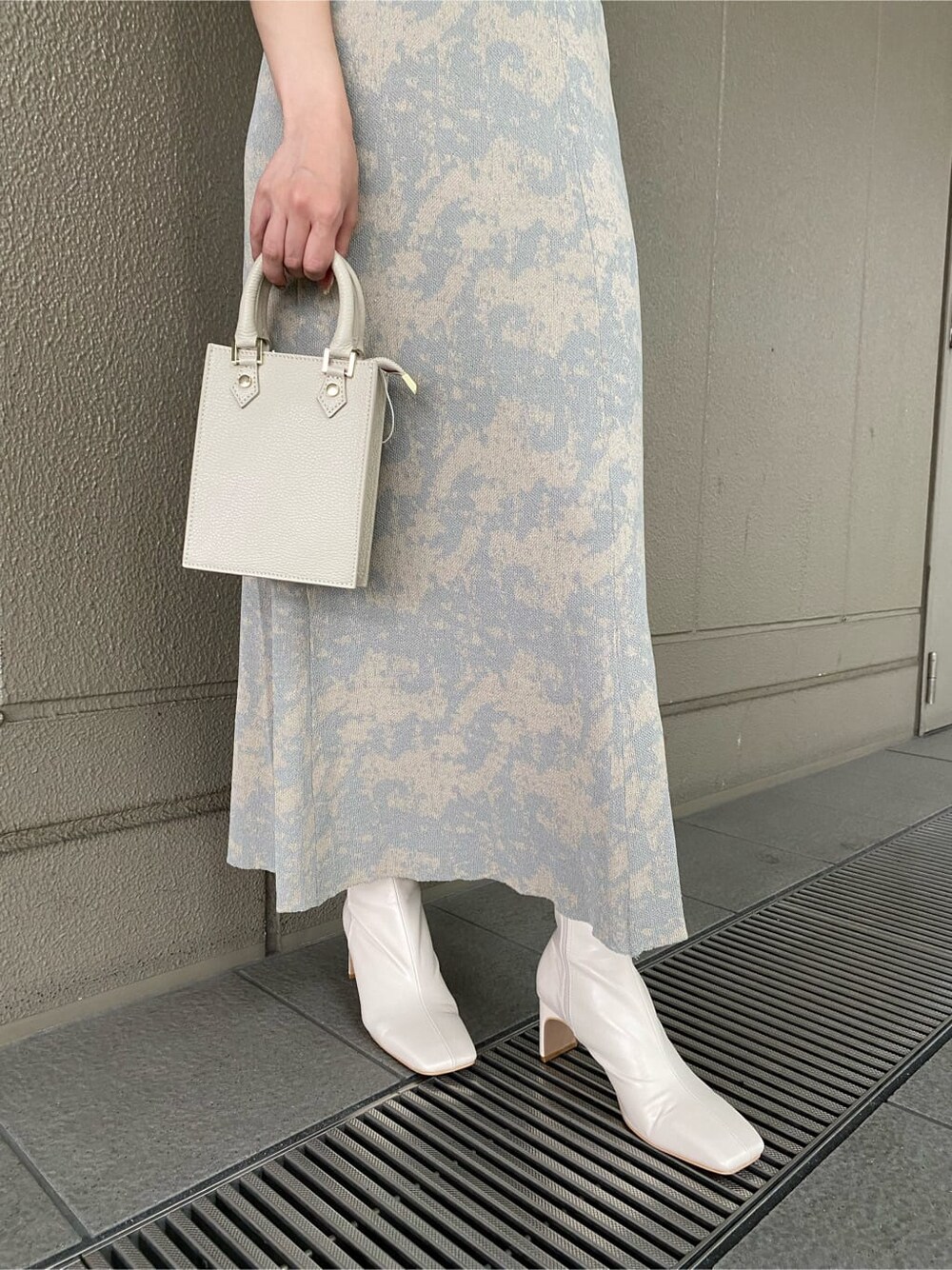 グレー系のスカート、ホワイト系のその他シューズ、ホワイト系のショルダーバッグを着用したレディースの夏コーディネートの6枚目の写真