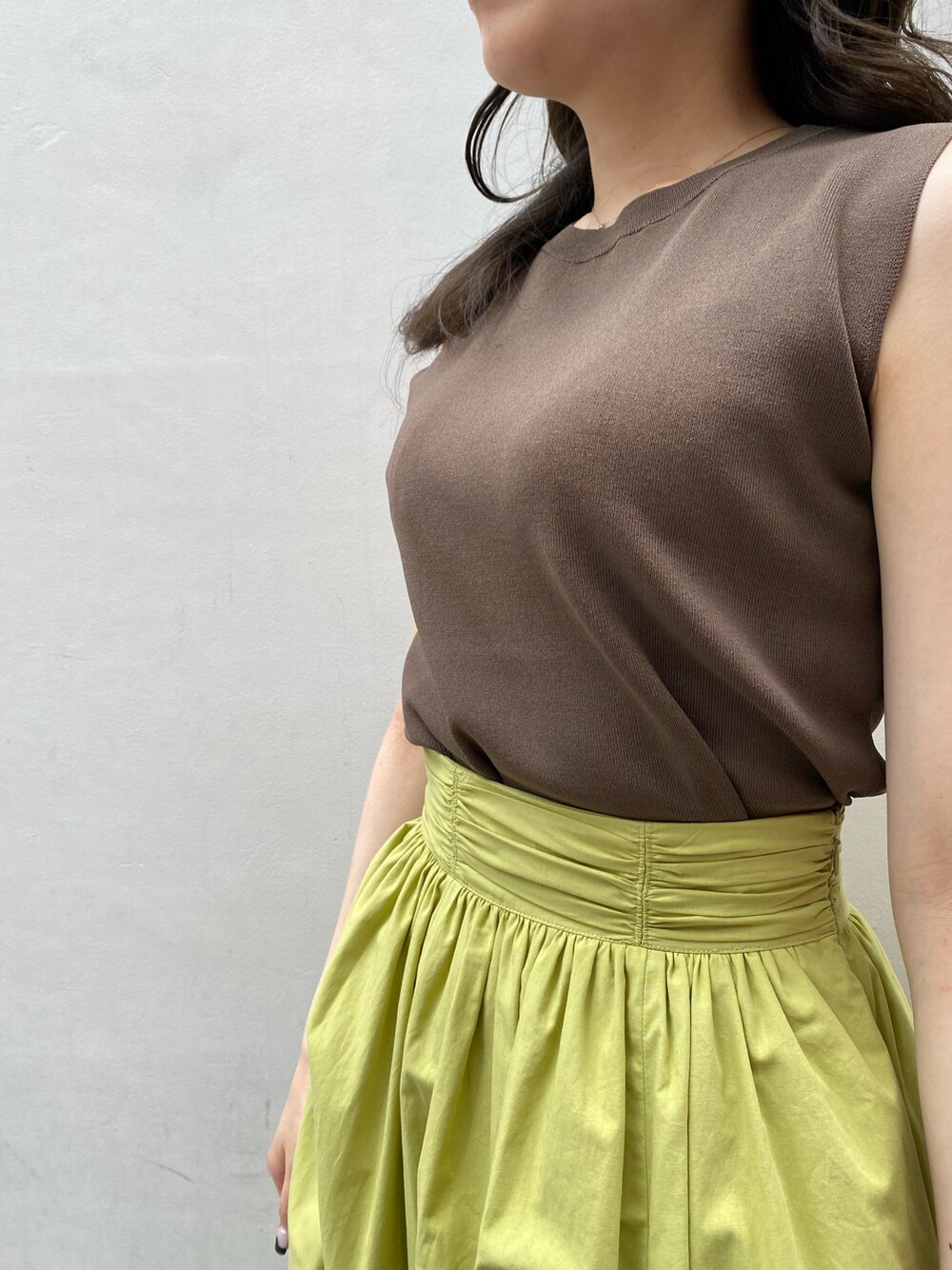 ブラウン系のニット/セーター、グリーン系のスカートを着用したレディースの夏コーディネートの4枚目の写真