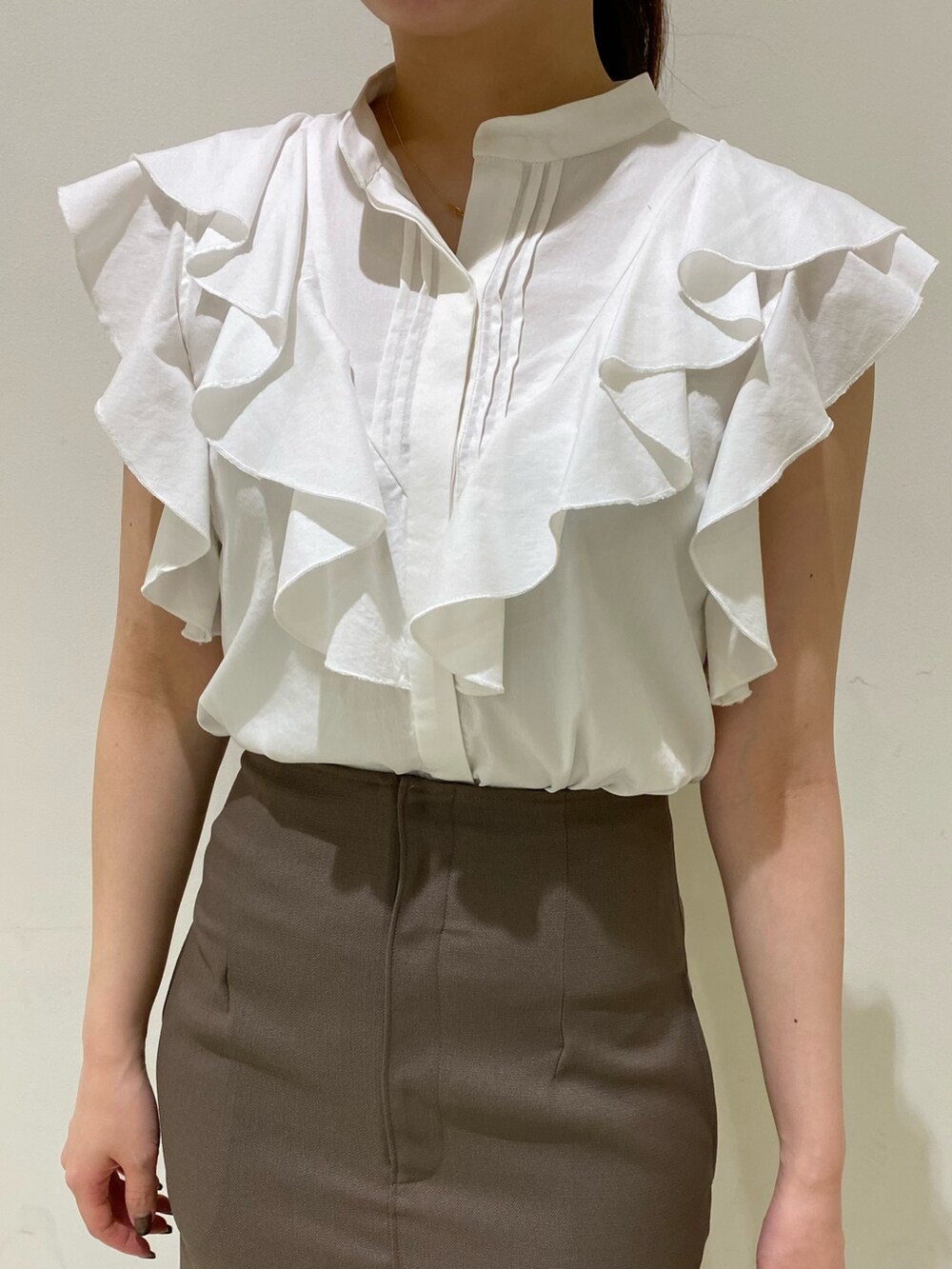 ホワイト系のシャツ/ブラウス、ブラウン系のスカートを着用したレディースの春コーディネートの2枚目の写真