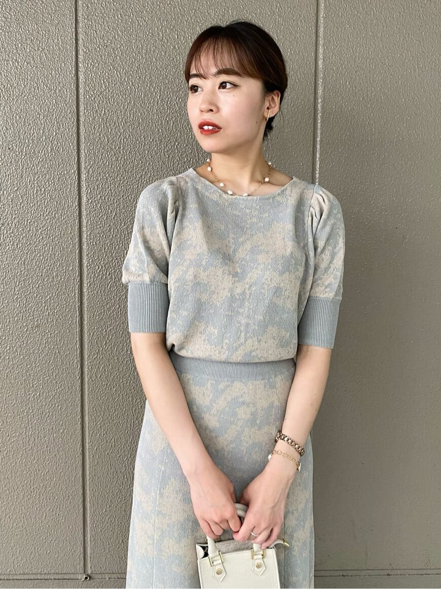 グレー系のスカート、ホワイト系のその他シューズ、ホワイト系のショルダーバッグを着用したレディースの夏コーディネートの3枚目の写真