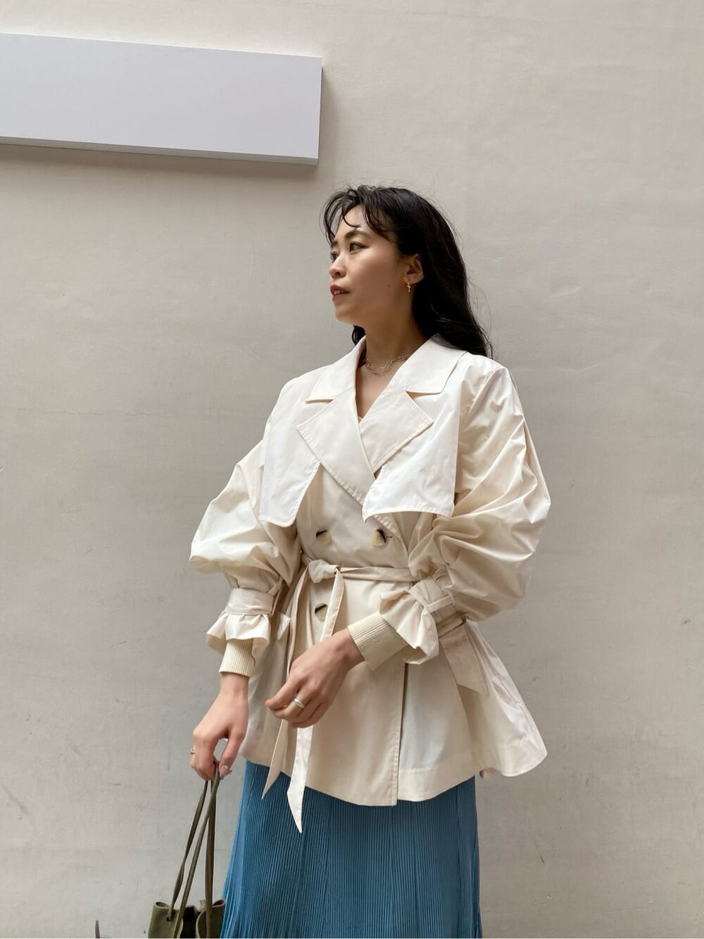 ブルー系のスカート、ベージュ系のブーツ、ホワイト系のニット/セーターを着用したレディースの春コーディネートの4枚目の写真