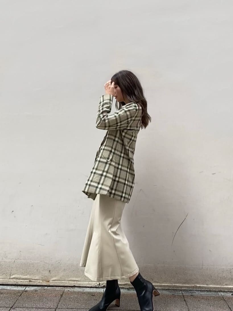 ホワイト系のスカート、ブラック系のその他シューズ、その他のテーラードジャケットを着用したレディースの秋コーディネートの2枚目の写真