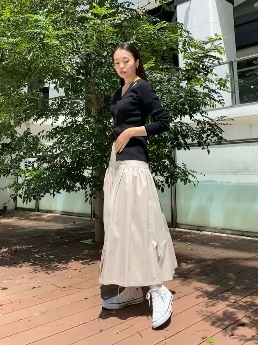 ベージュ系のスカート、ブラック系のニット/セーターを着用したレディースの秋コーディネートの3枚目の写真