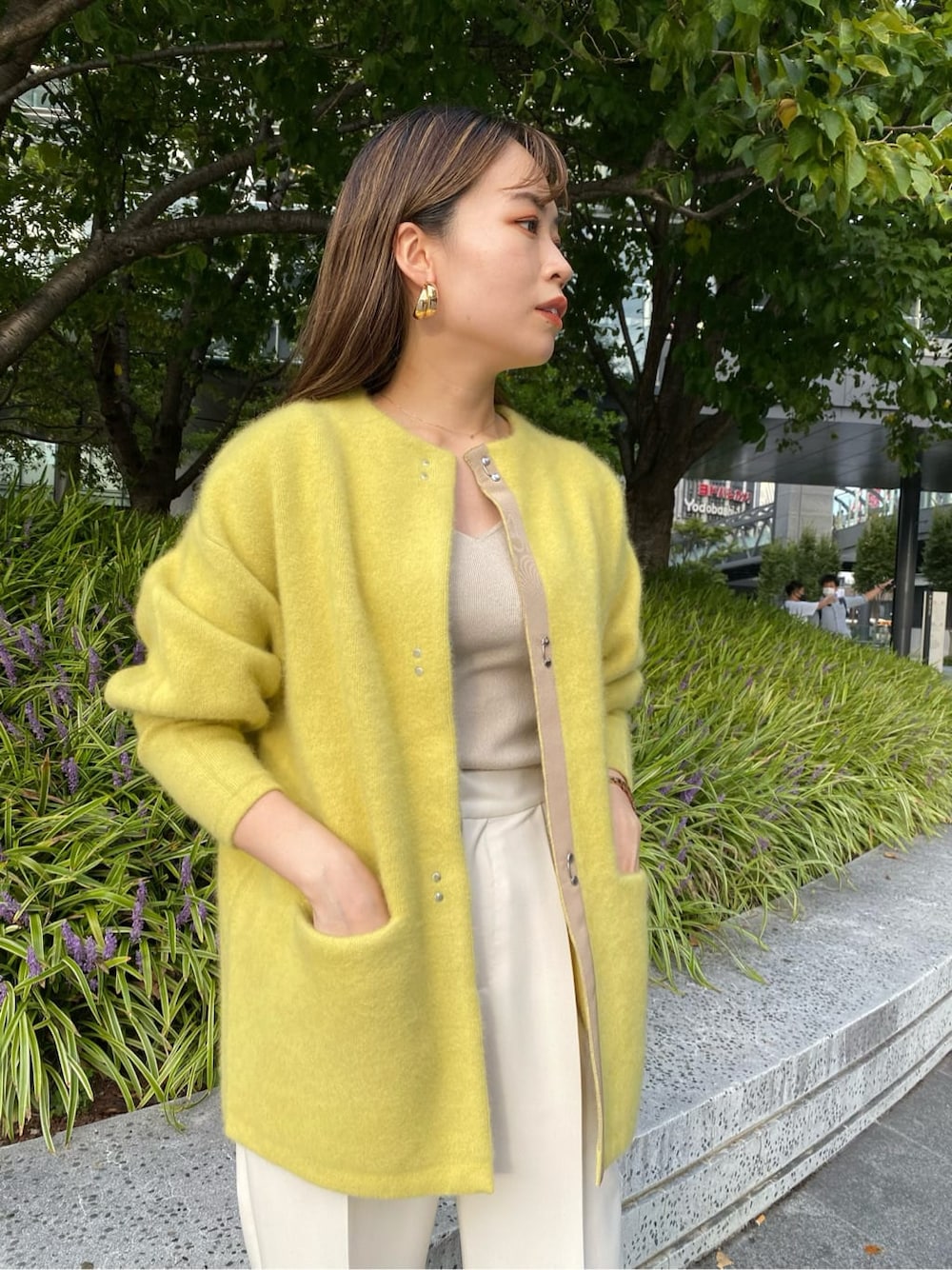 ホワイト系のステンカラーコート、ホワイト系のその他パンツ、ホワイト系のハンドバッグを着用したレディースの秋コーディネートの7枚目の写真